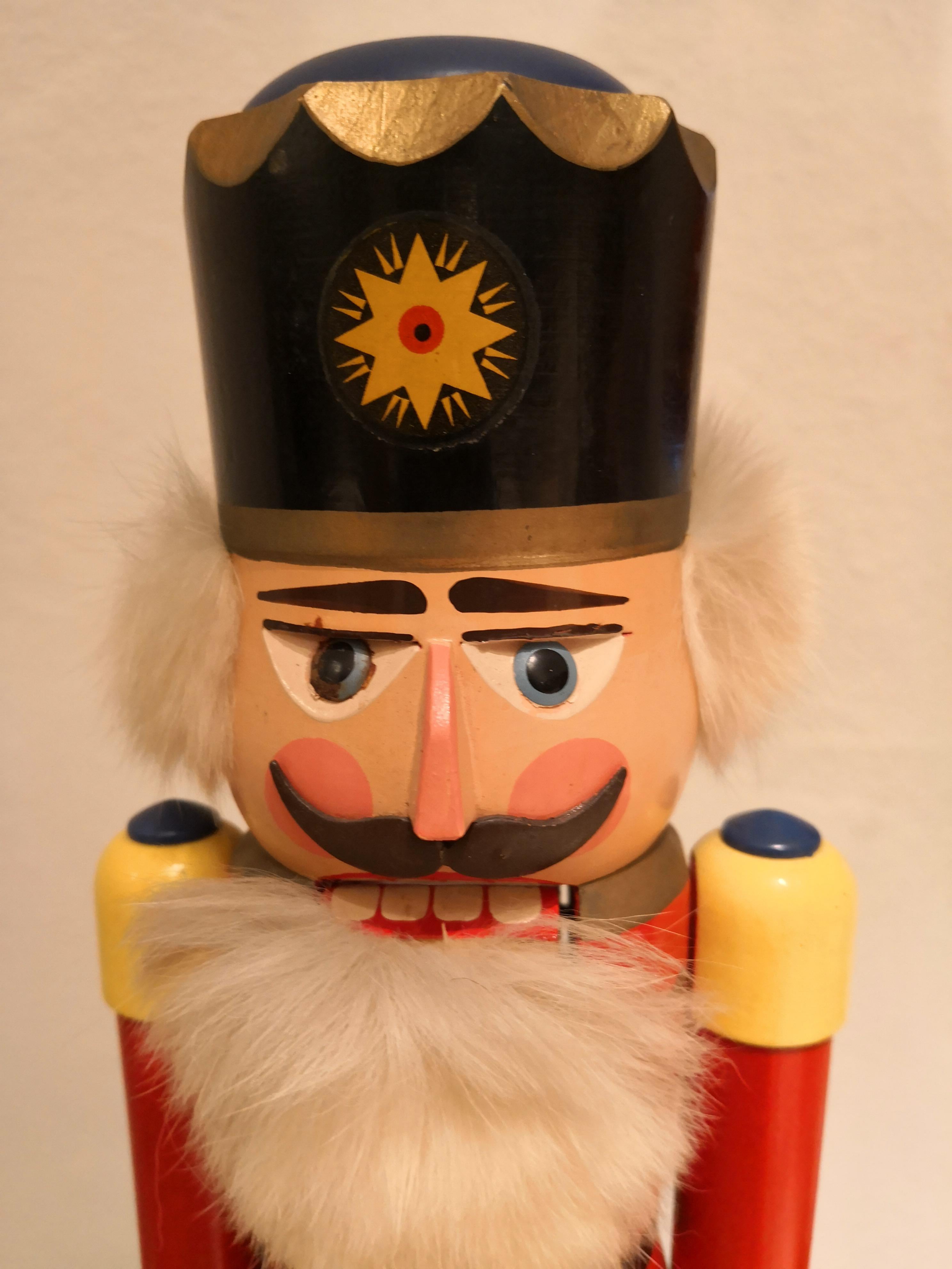 Large wooden nutcracker figure from the Erzgebirge. The region Erzgebirge formerly Eastern Germany is famous for this special kind of nutcrackers, where intricate carving has been their home. Completely hand-painted in bright colors and decorated