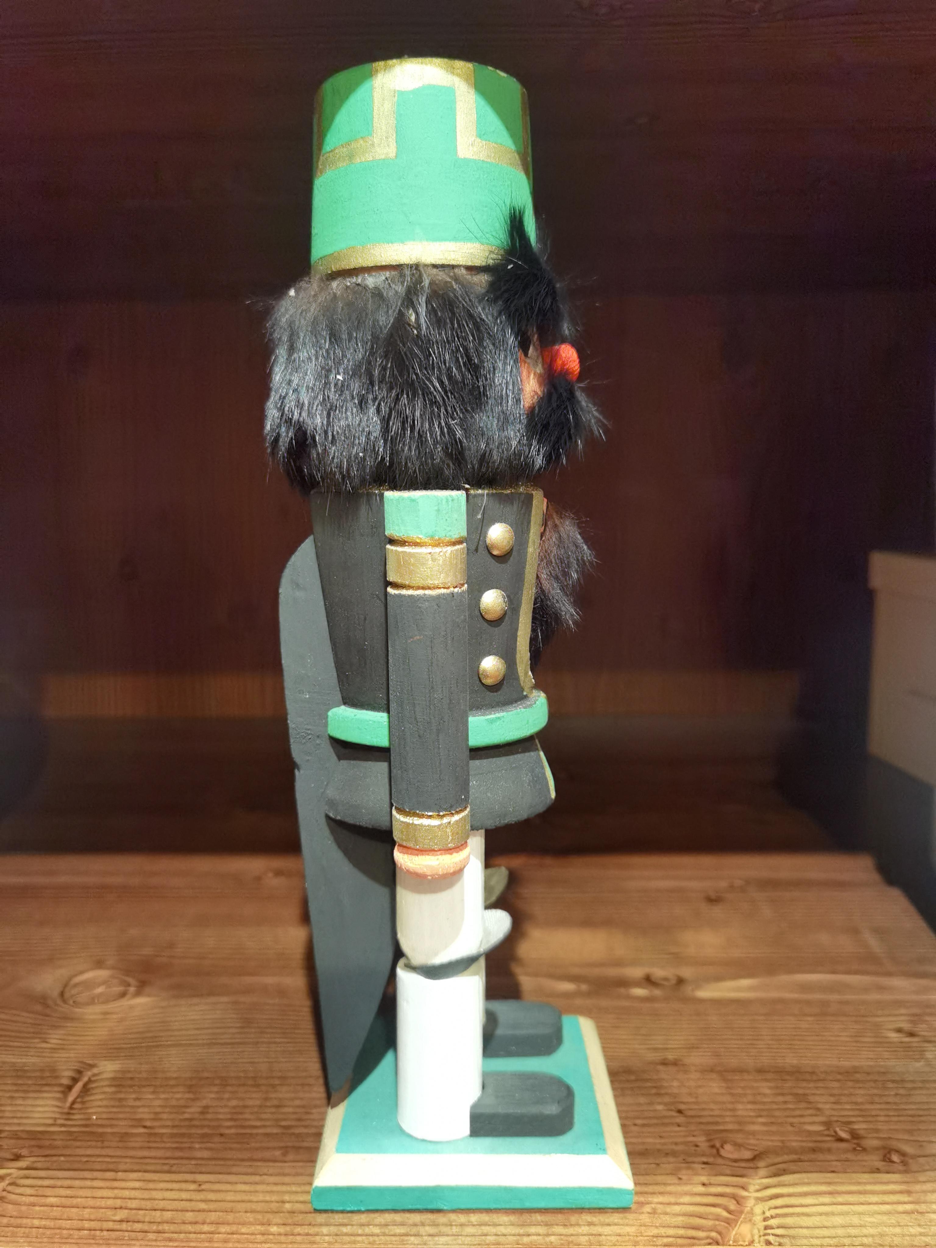 Vintage wooden nutcracker figure from the Erzgebirge. The region Erzgebirge formerly Eastern Germany is famous for this special kind of nutcrackers, where intricate carving has been their home. Completely hand-painted in green and black colors and