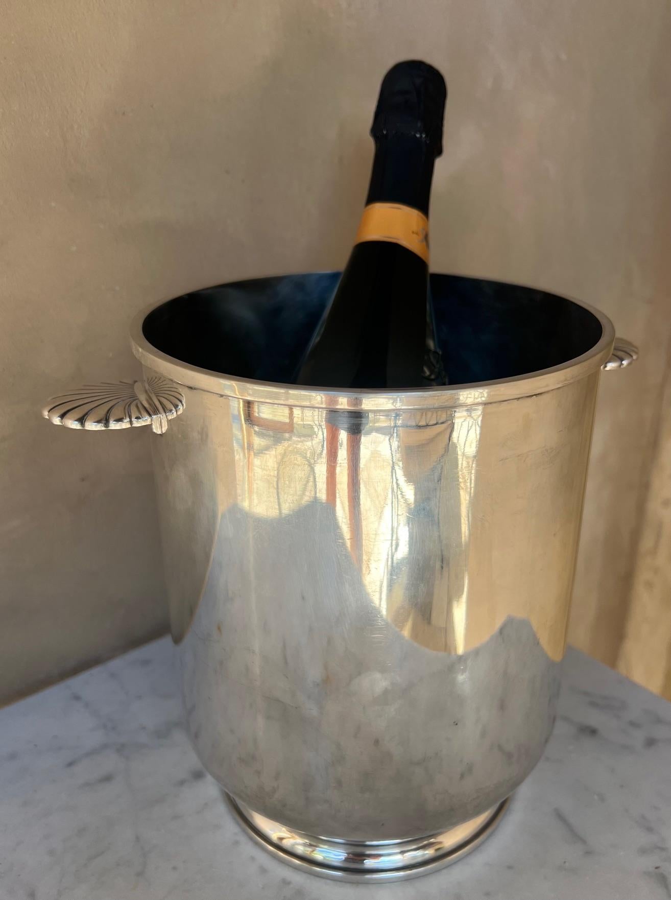 Champagne / Wine bucket made by Christofle in France in the Mid 20th century. Made of heavy silverplating, the pattern is an Art Deco style with a footed base and two shell form handles.

The stamp on the bottom was used by Christofle from 1935 -