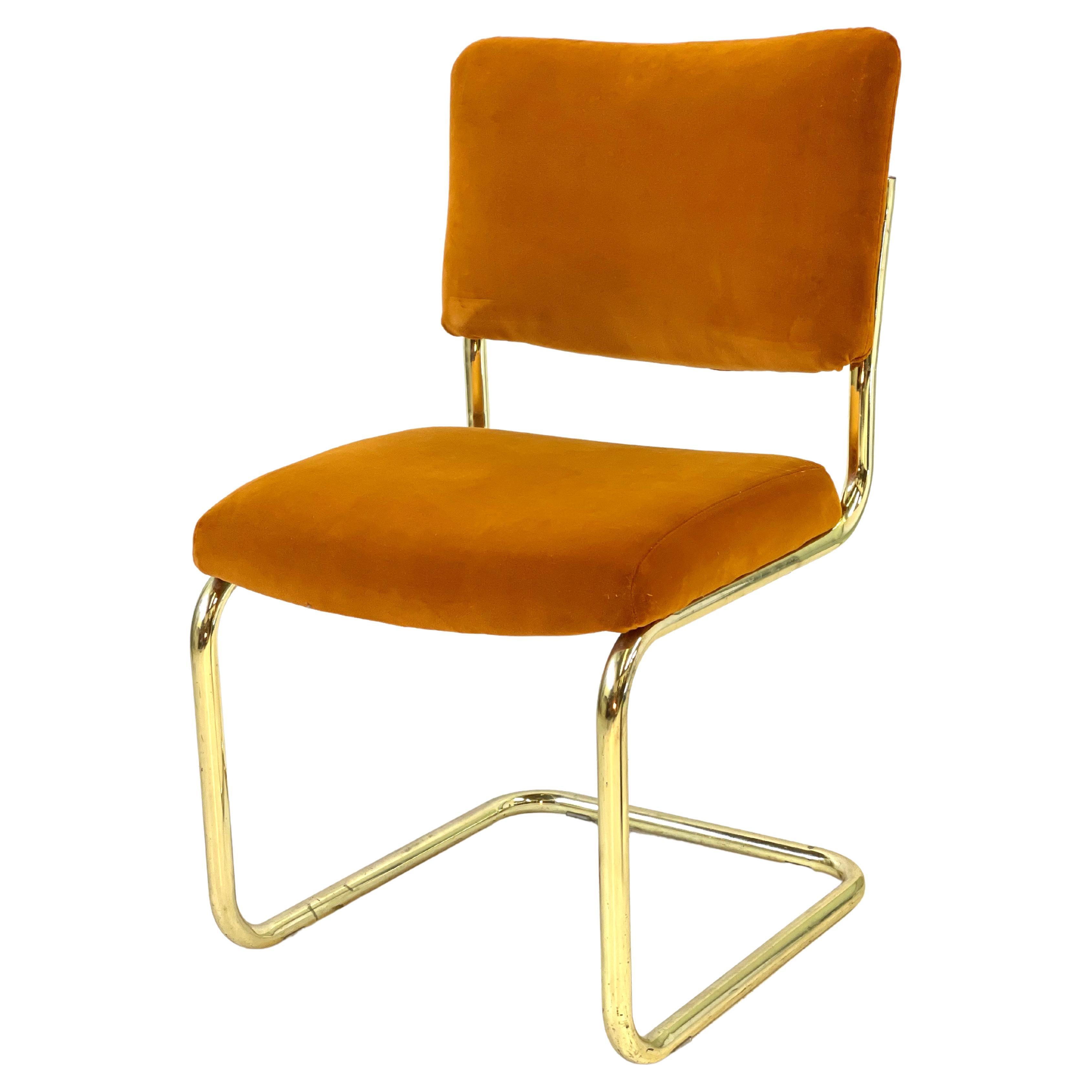 Classic mid-century style cantilever side chair with tubular brass frame manufactured by Chromcraft. The chair seat and back have been newly upholstered in a pumpkin Jim Thompson velvet. This would make a lovely occasional chair or home office chair!