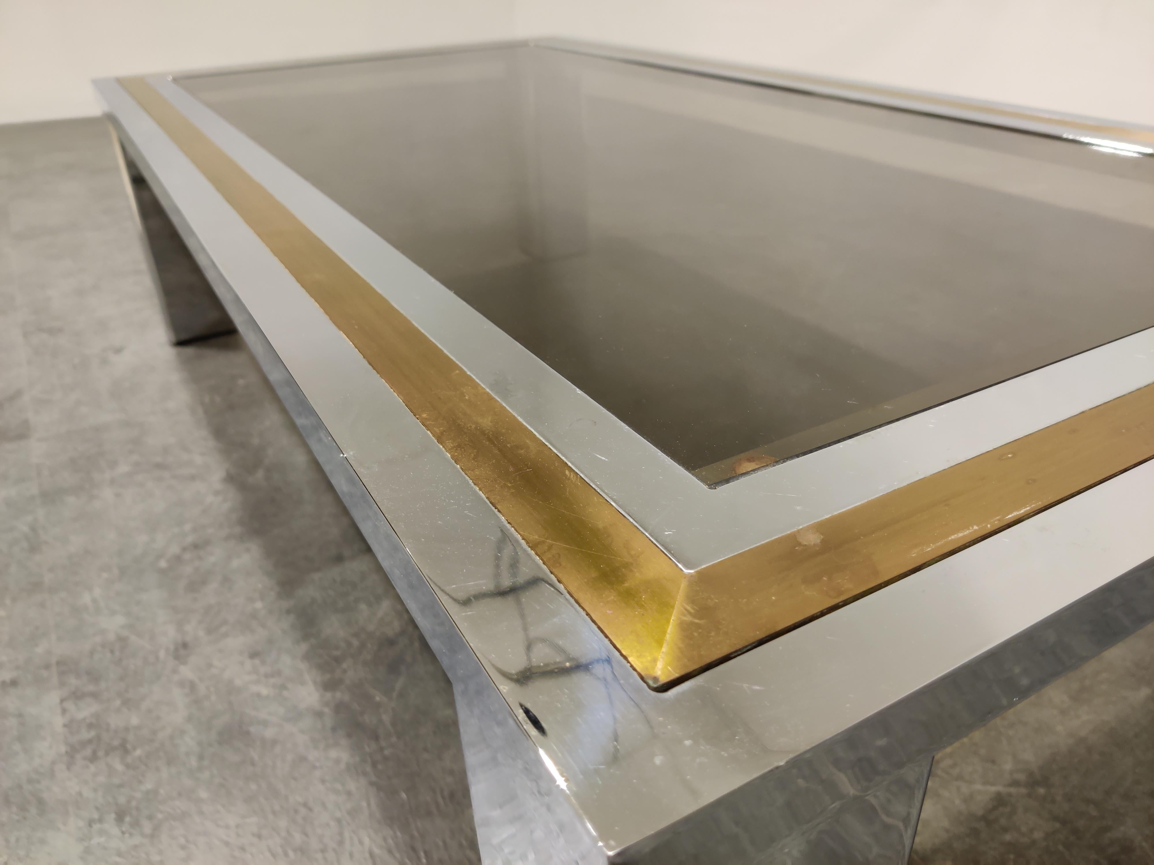 Chrome and brass coffee table with a smoked glass top in the style of Willy Rizzo or Romeo Rega

Hollywood regency style.

Condition: Patina on the brass/chrome, original glass top with minor scratches,

1970s, Belgium

Dimensions:
Height