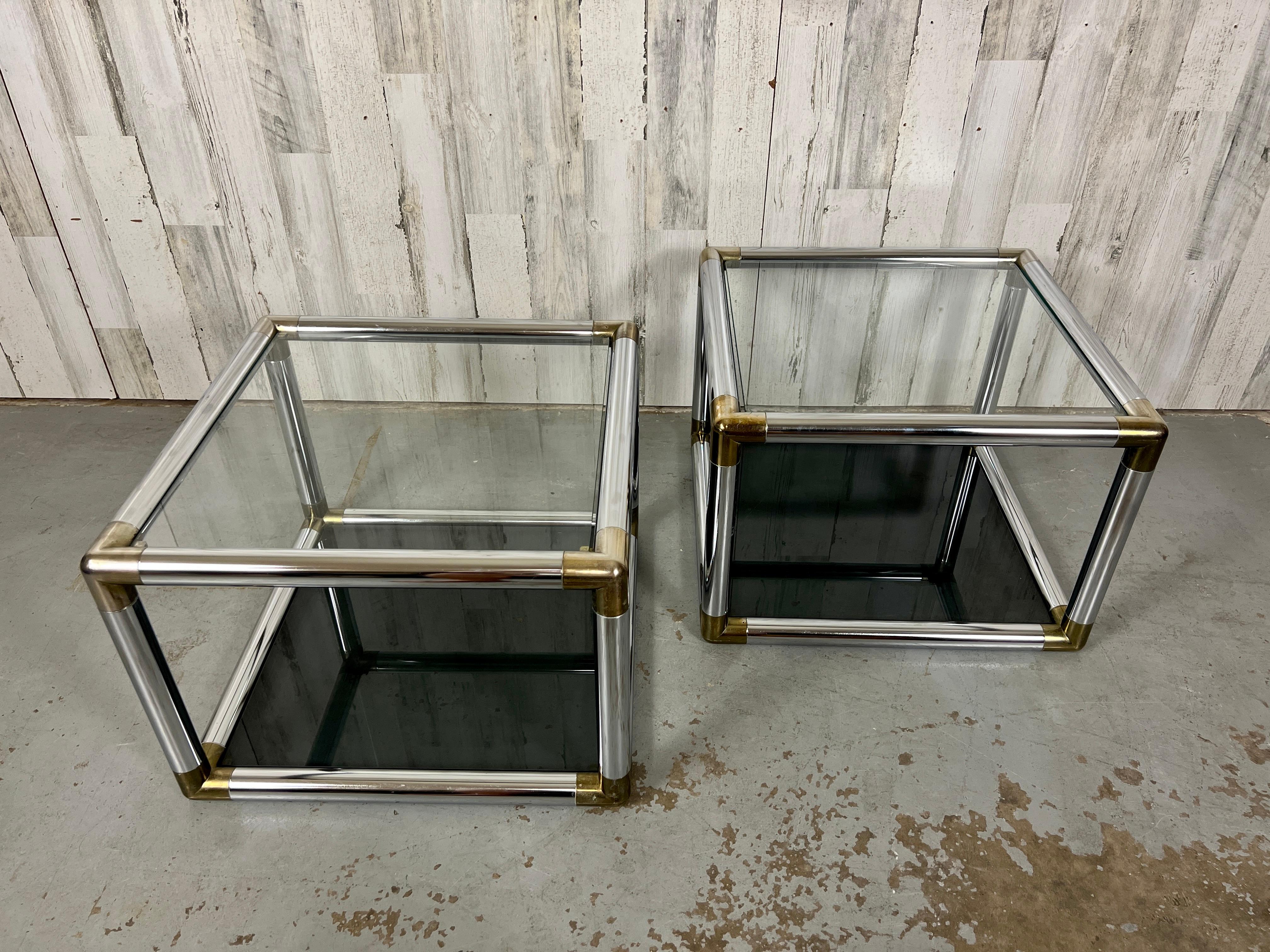 Cube chrome, brass and glass side tables in the style of Milo Baughnan. the top glass is clear and the bottom glass is smoked 