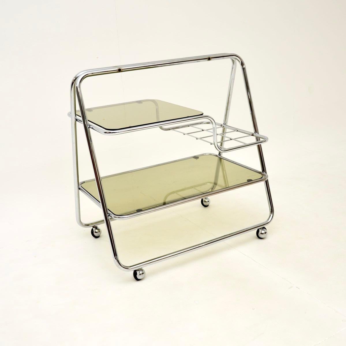 Un chariot à boissons vintage en verre et chrome très élégant et bien fait. Il a été fabriqué en Angleterre, il date des années 1970.

Il est de très bonne qualité et son design est très utile. Les étagères en verre sont amovibles, le plus petit