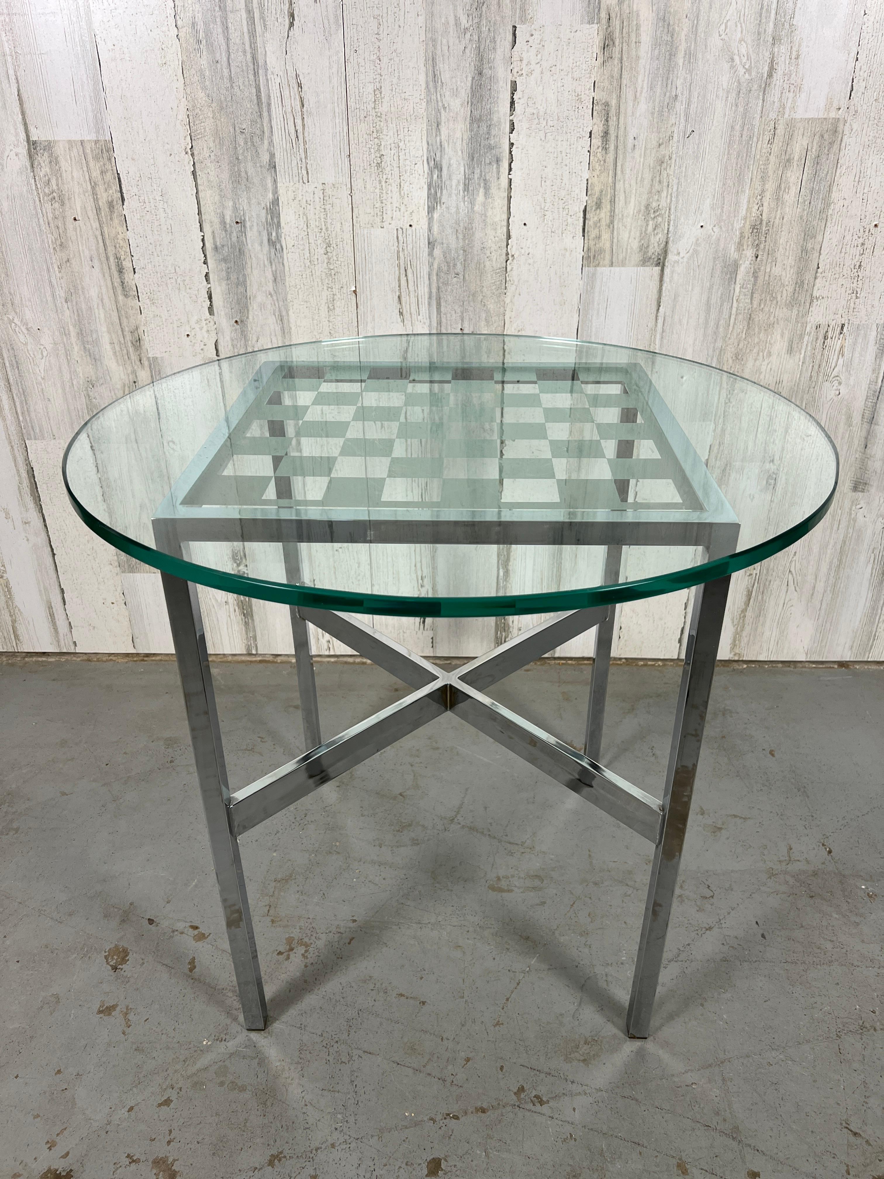 Small chrome table base with X shaped stretcher with a thick glass chess board top. It's a great size for an end table. Chrome is in very good condition, some minor wear on the game surface. Please see pictures.