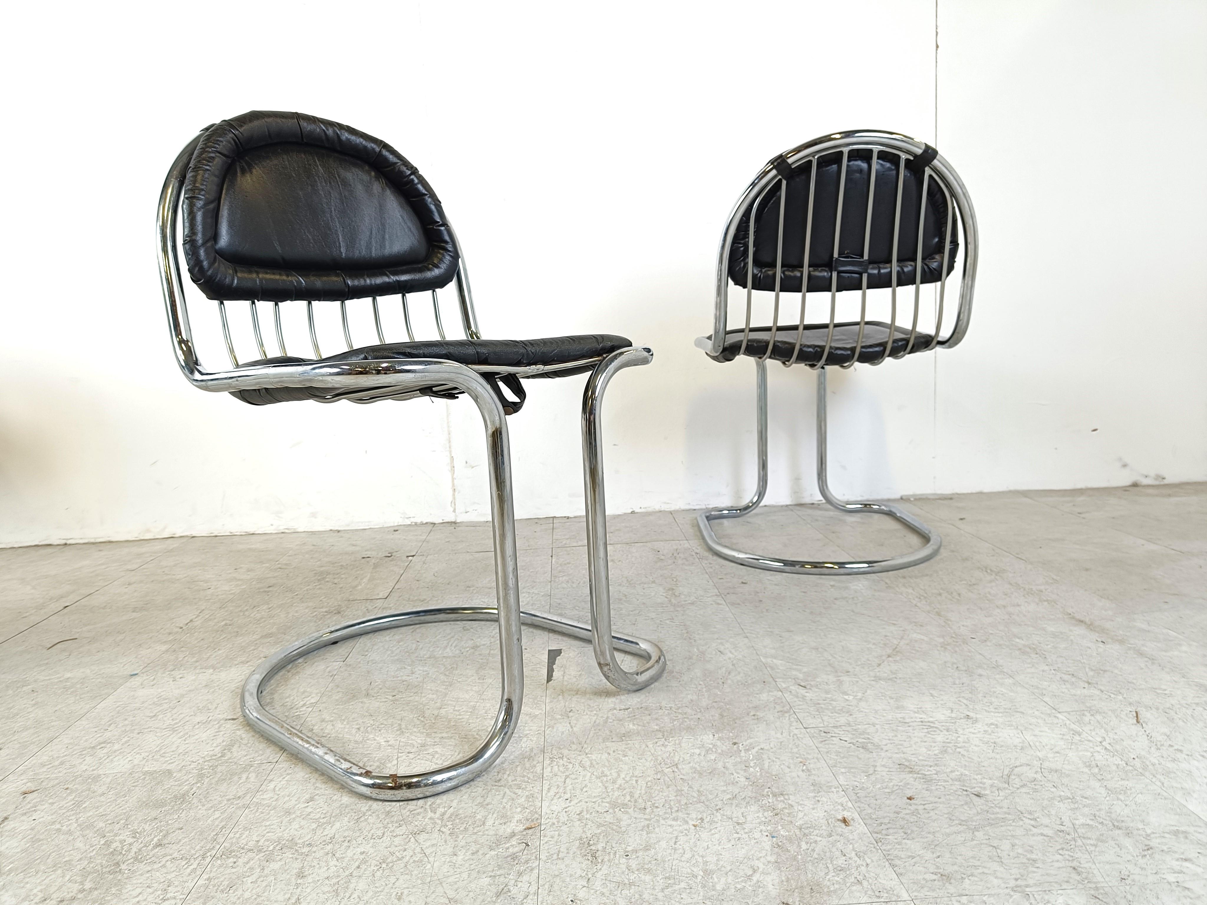 Mid century chrome wire and cantilever dining chairs with black leather cushions, set of 4.

Striking design with an unusually shaped base.

1970s, Italy

Attributed to Gastone Rinaldi, Giotto Stoppino

Dimensions:

Height: 83cm/32.67