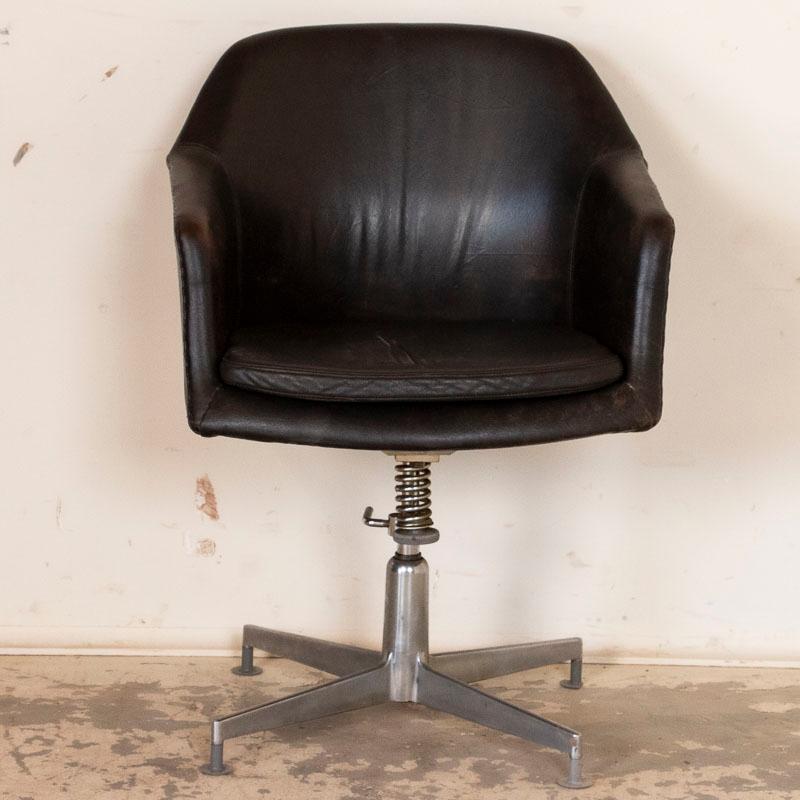 This original vintage office chair has very dark brown leather that almost looks black and is accented with chrome. The leather is in good used condition, showing more wear, scratches etc along the back where it likely rubbed against a wall. Seat