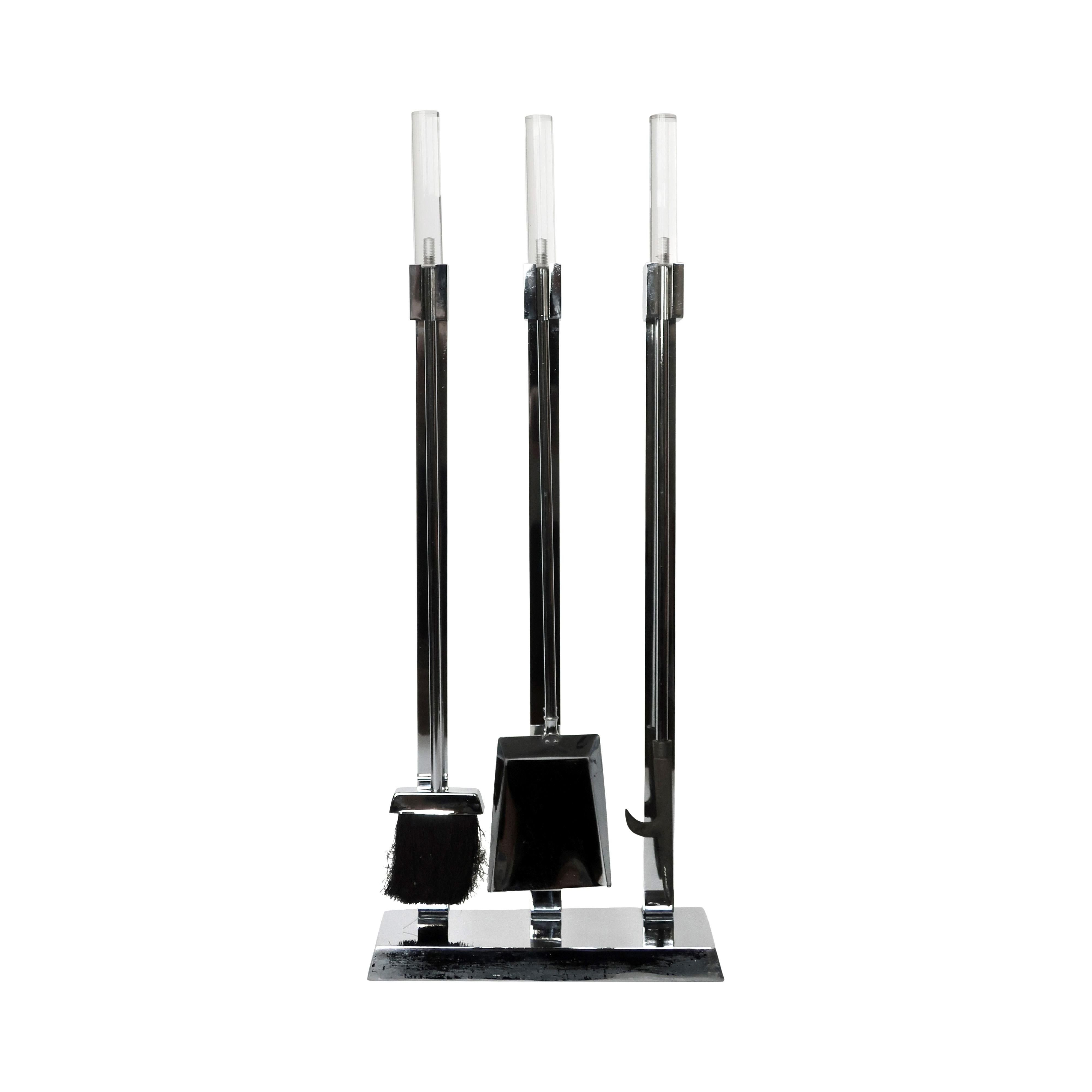 A lovely three piece set of lucite topped chrome fireplace tools that includes a shovel, brush, poker and stand. Each tool is chrome with a cylindrical lucite handle, which rest on the upright stands of the base. In the style of some of the greats