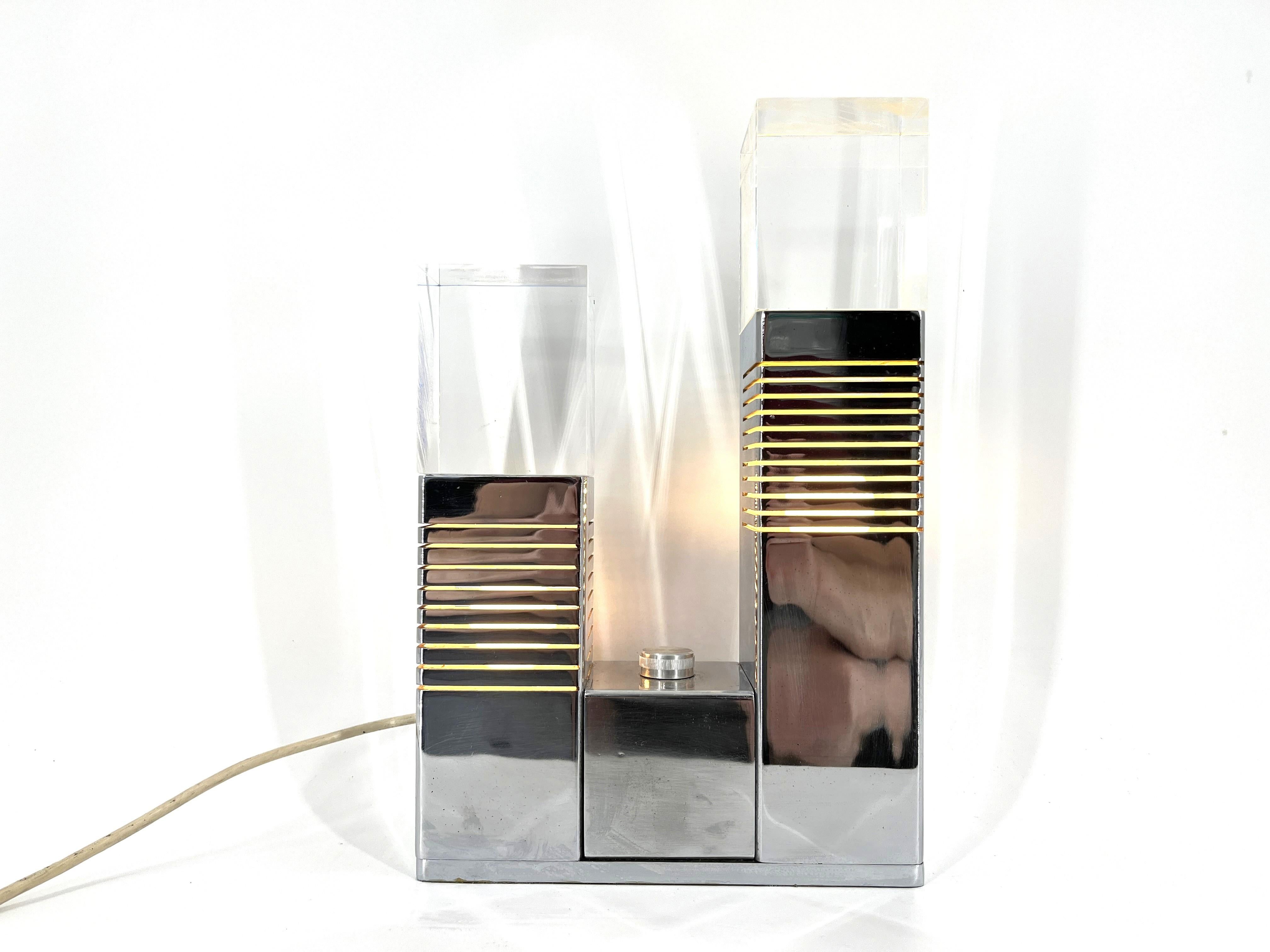 Rara Lámpara de sobremesa de diseño geométrico atribuida a Gaetano Missaglia.

Esta lámpara atemporal está fabricada en cromo y tiene dos tapas de plexiglás que sirven para difundir la luz. 

Además, la lámpara tiene un reflector azul y amarillo en