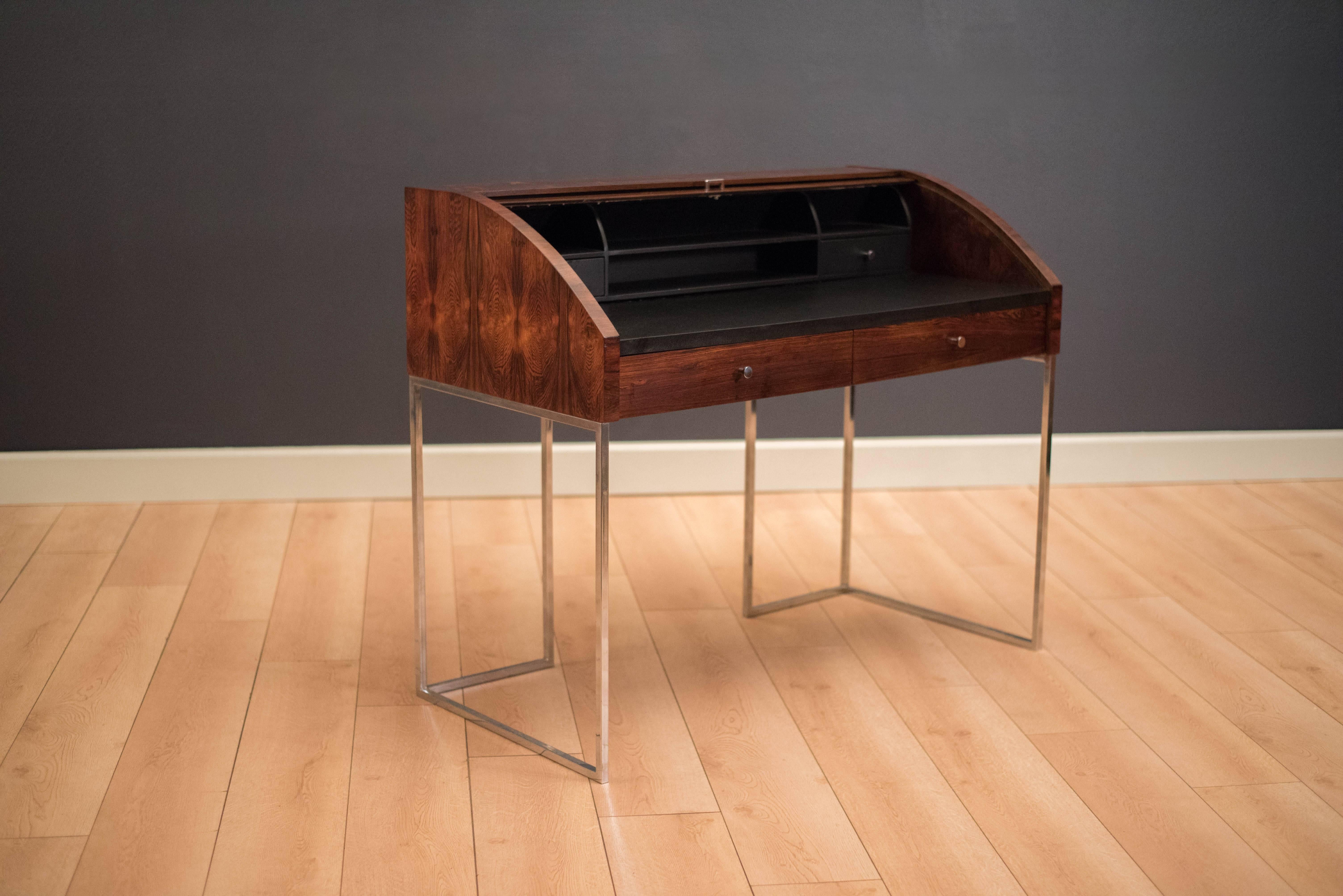 Mid-Century Modern roll top secretary desk manufactured by Sligh Furniture in rosewood and chrome. This piece features a writing top lined with black leather and two external drawers below. Interior of desk includes open storage compartments with