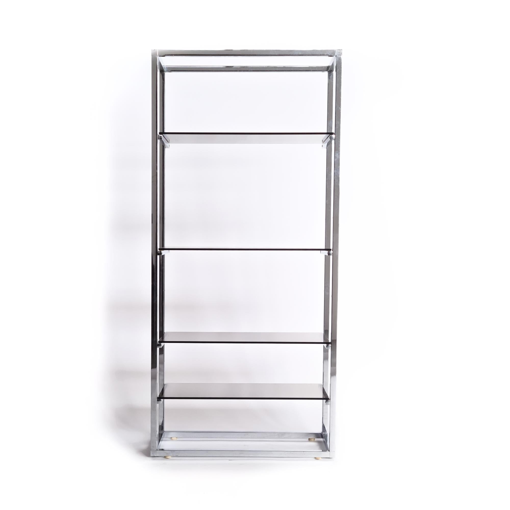 This elegant vintage shelving unit features a sturdy chrome frame and comes with four stylish smoked glass shelves. The combination of chrome and smoked glass gives it a sleek, modern look, making it perfect as a bookcase or display unit in any