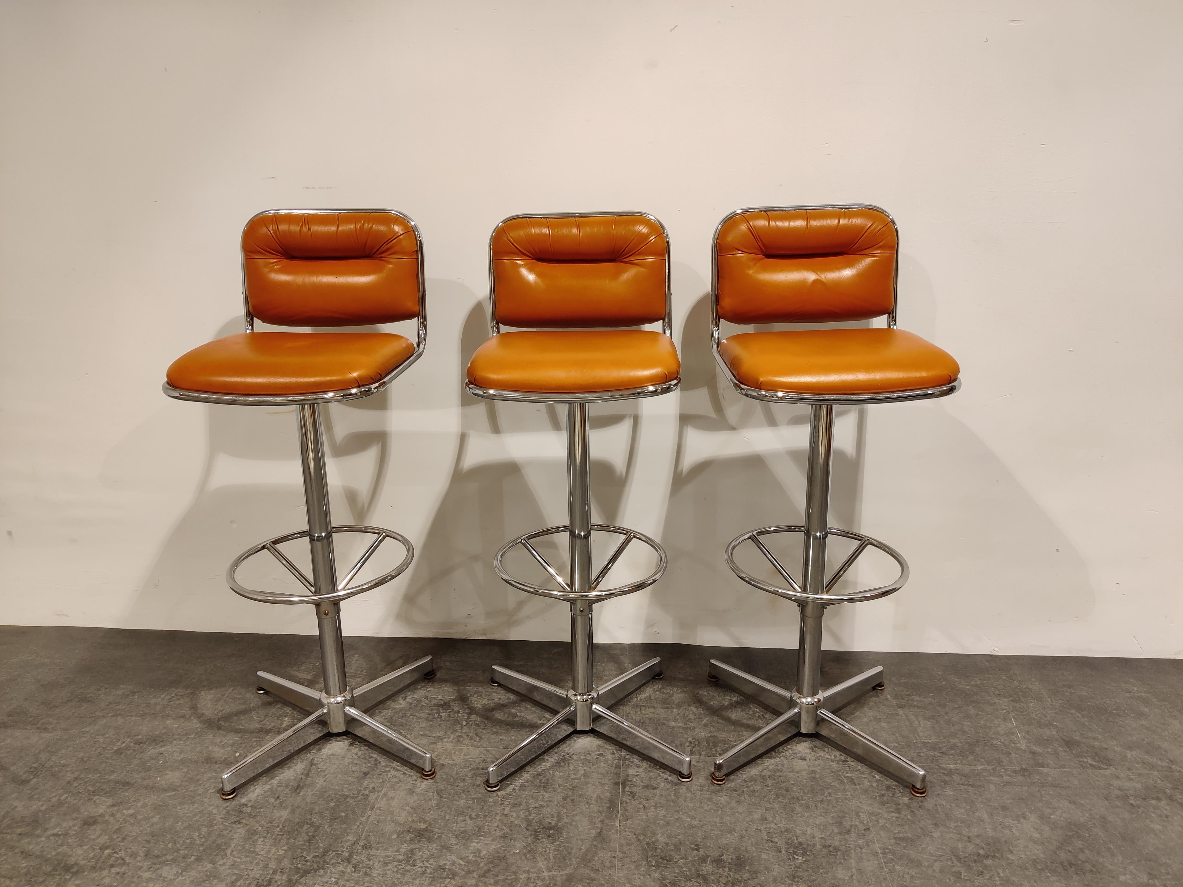 Vintage Space Age era bar stools with chromed metal bases and orange skai (faux leather) upholstery.

Good condition

1970s - Belgium

Dimensions:
Height: 111cm/43.70
