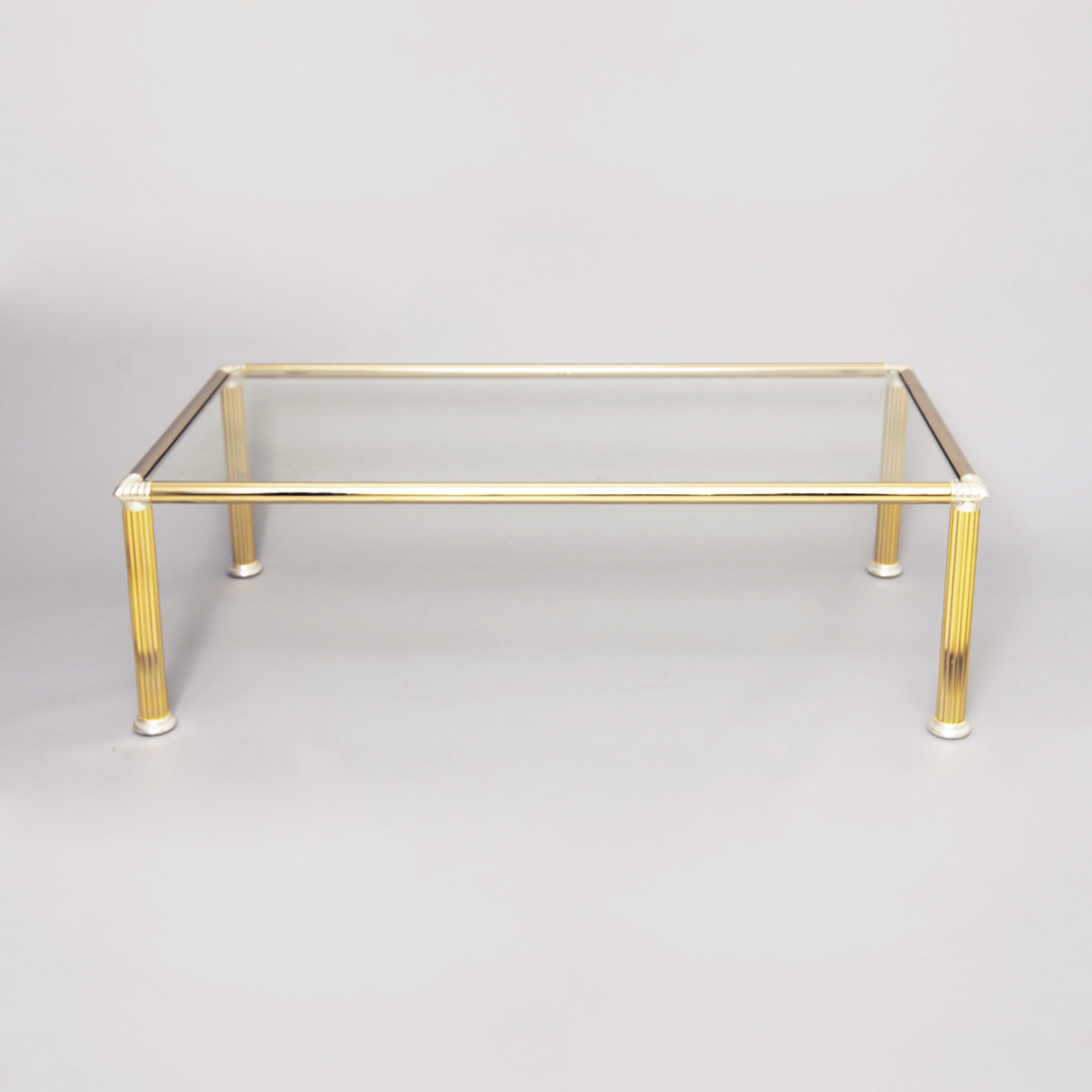 Chrome and brass-plated rectangular coffee table with column shaped legs and corners. Clear glass top.