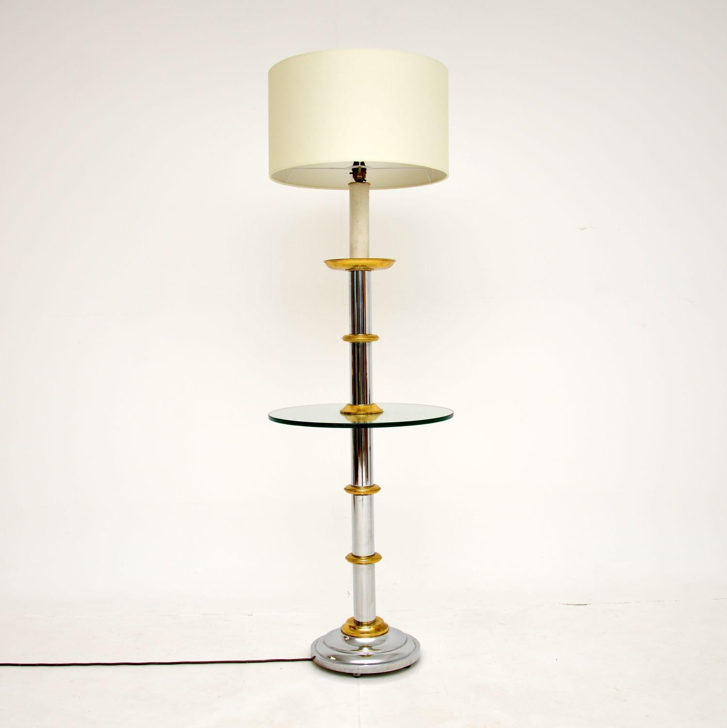 An excellent vintage floor lamp in chrome and brass, with a circular glass table built in. This was made in England, it dates from around the 1970-1980’s.

It is of fantastic quality, the glass is thick and toughened, the alternating chrome and