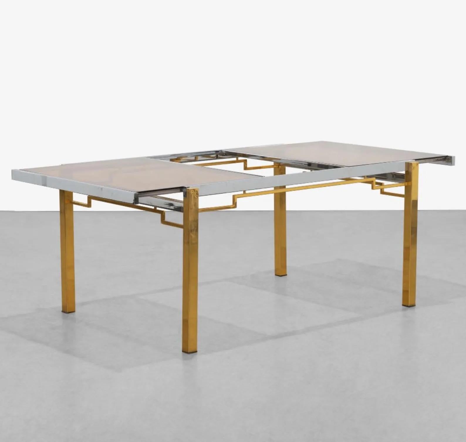 Table de salle à manger vintage avec une structure en métal chromé et laiton et un plateau en verre teinté ambre. Le plateau se sépare pour accéder au mécanisme interne d'une feuille de 21