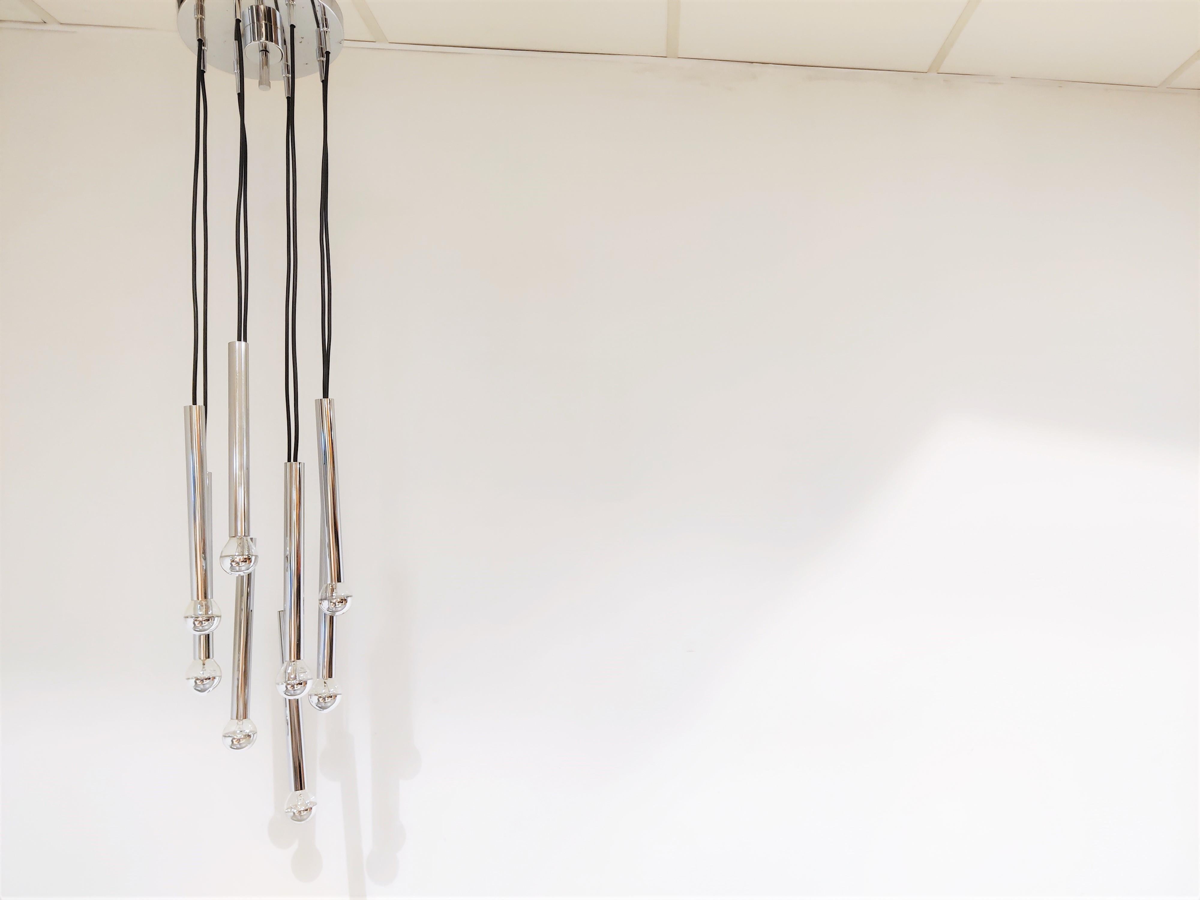 Eye catching mid century cascading chandelier with chrome tubes.

The chandelier consists of 8 lights.

Chrome ceiling cap.

Works with regular E14 light bulbs.

Tested and ready for use.

The height of the different tubes can be