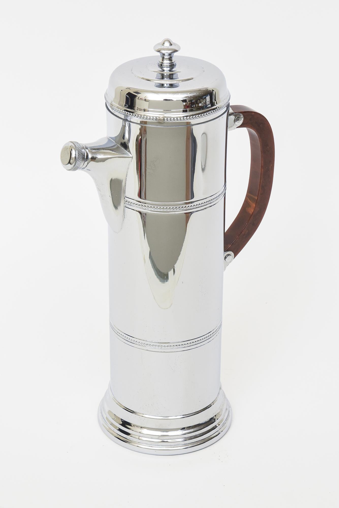 This great art deco moderne tall chrome cocktail shaker is from the 40's and has a great brown bakelite handle. It was polished to the best it can be. From side to side inclusive of the bakelite handle to the pouring spout it is 7.5