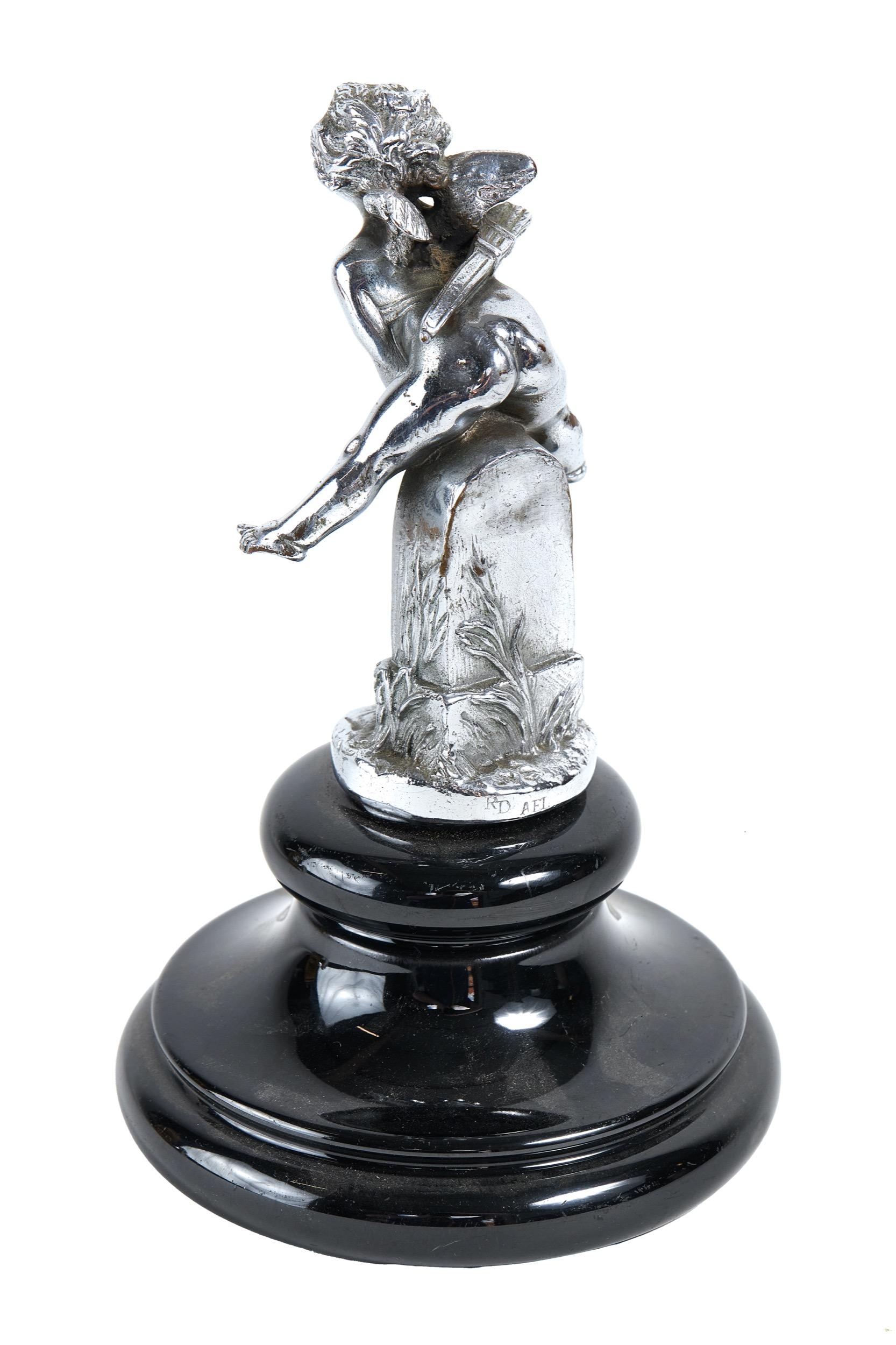 Vintage Chrome Plated Car mascot 
in the form of Cupid vaulting road marker CYTHERE 22KM , 
chrome plated on brass ,
 signed A.RENEVEY RD AEL
circa 1930, original car mascot.
[there has been a hole drilled in base of mascot]
Dimensions H 14.5cm x W