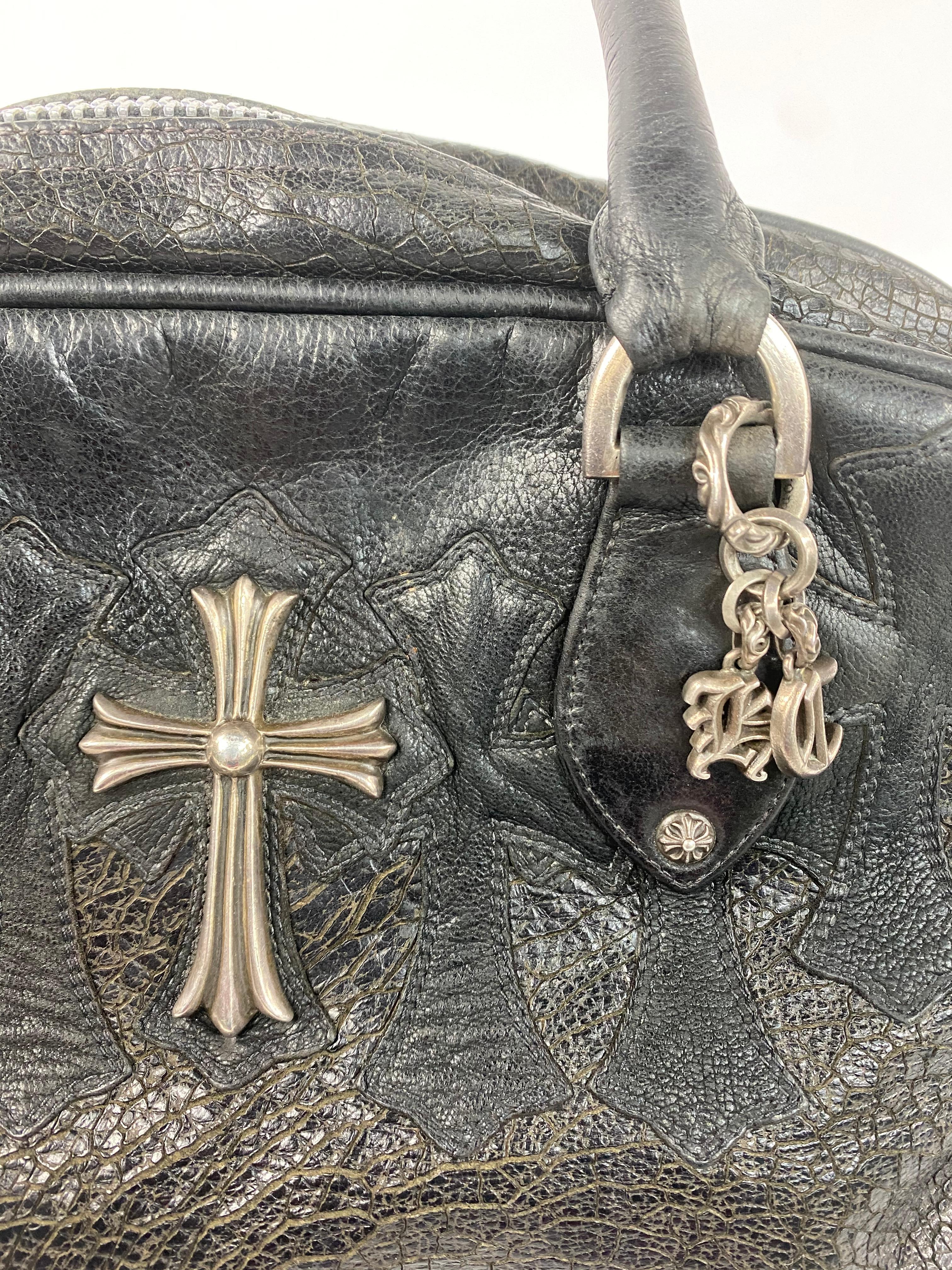 Product details:

The bag is designed by Chrome Hearts. It features black leather with silver hardware details and cross pattern design. The bag has zip closure with interior pocket detail as well as pockets for pens and credit or business cards.