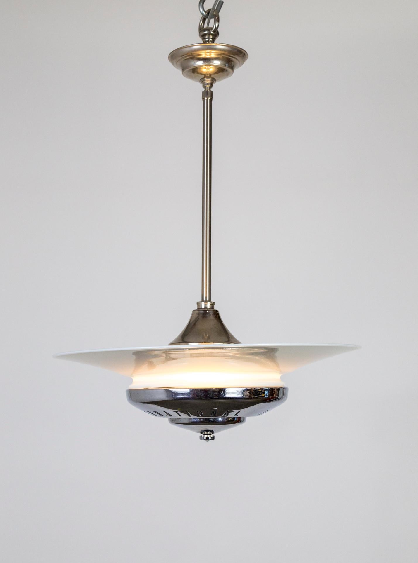 A pendant light with a vintage, chrome hubcap base supporting a milk glass disk shade with complimenting stem and canopy. 3-light medium base cluster. Newly made with new and vintage parts. Measures: 19.5