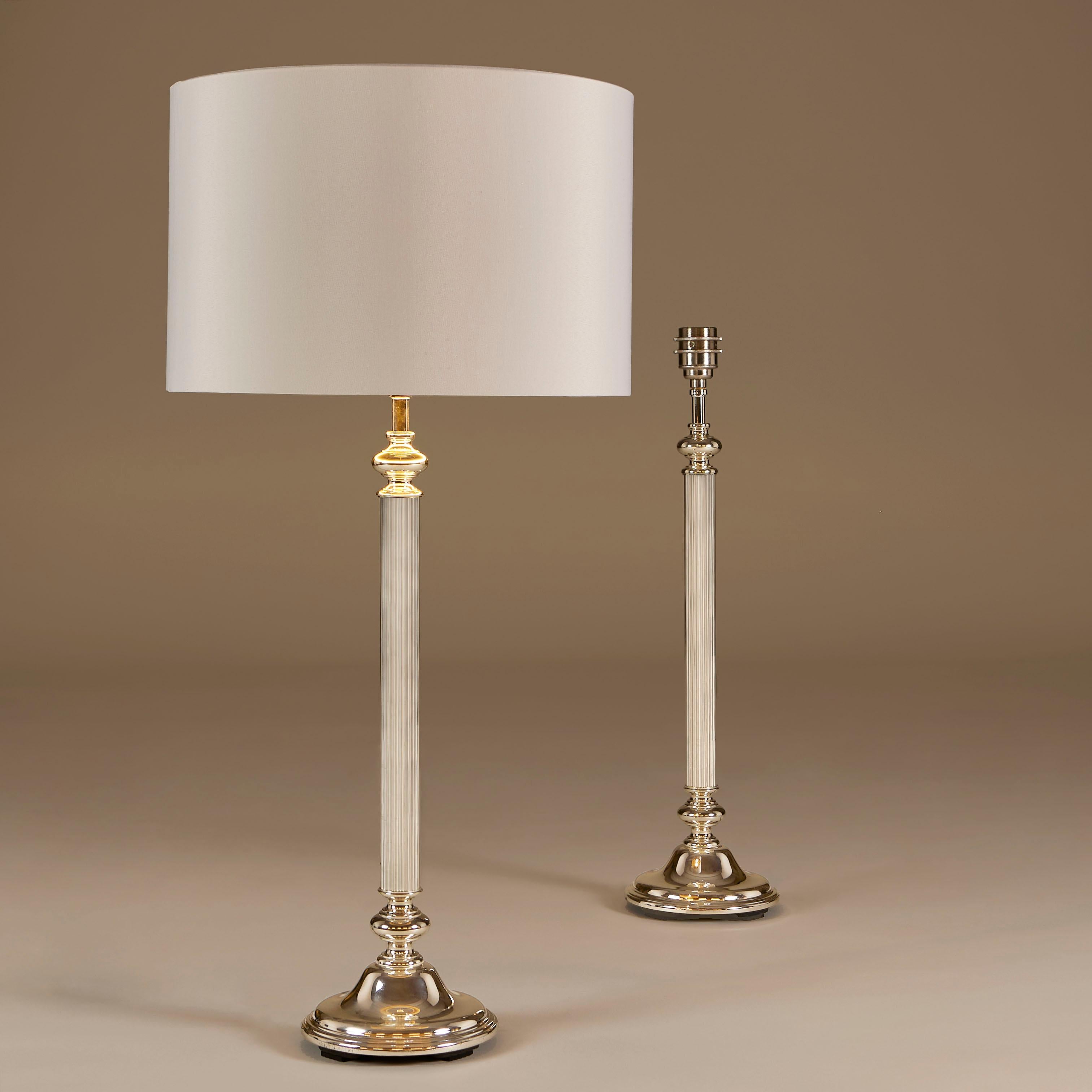Pratica e chic coppia di lampade da tavolo in cromo con base decorativa curva e stelo finemente scanalato.
I paralumi sono opzionali.