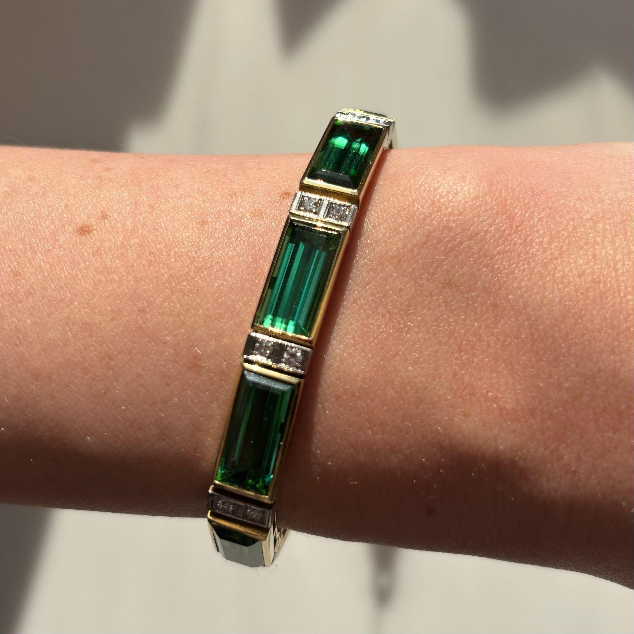 A truly stunning chrome tourmaline and diamond panel bracelet set in 18k yellow gold. 

The bracelet is composed of ten chrome tourmalines, each rub over set in yellow gold to create a panel design. Between each tourmaline is a terminal of two round