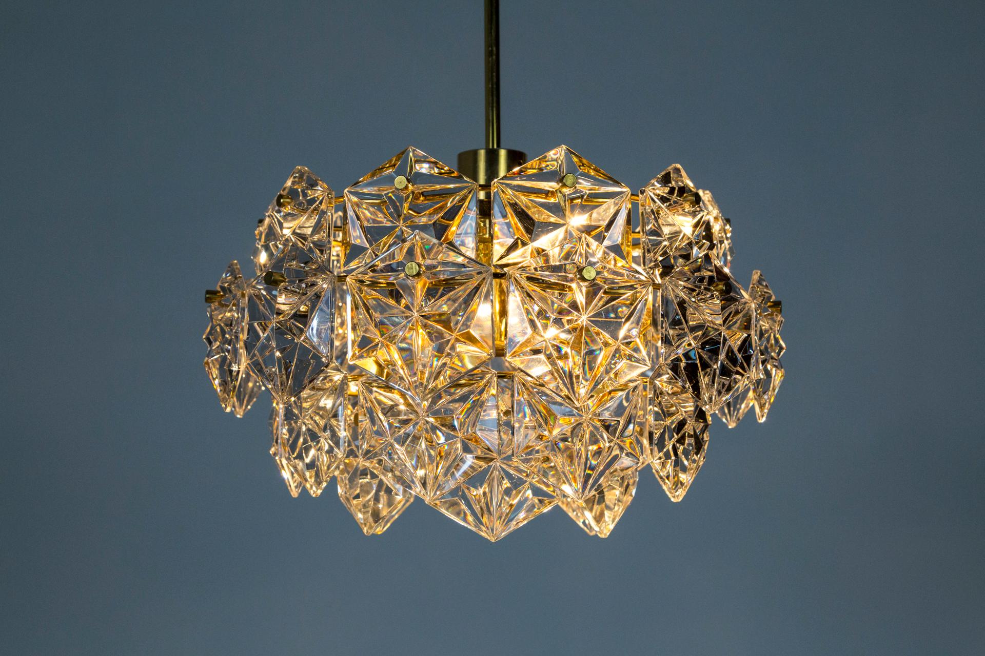 A vintage, Kinkeldey pendant made of a cluster of 4-tiers of chunky, gem-like crystal glass, with gold-plated brass hardware. A sparkling appearance. Made in Germany in the 1960s. Measures: 29.5