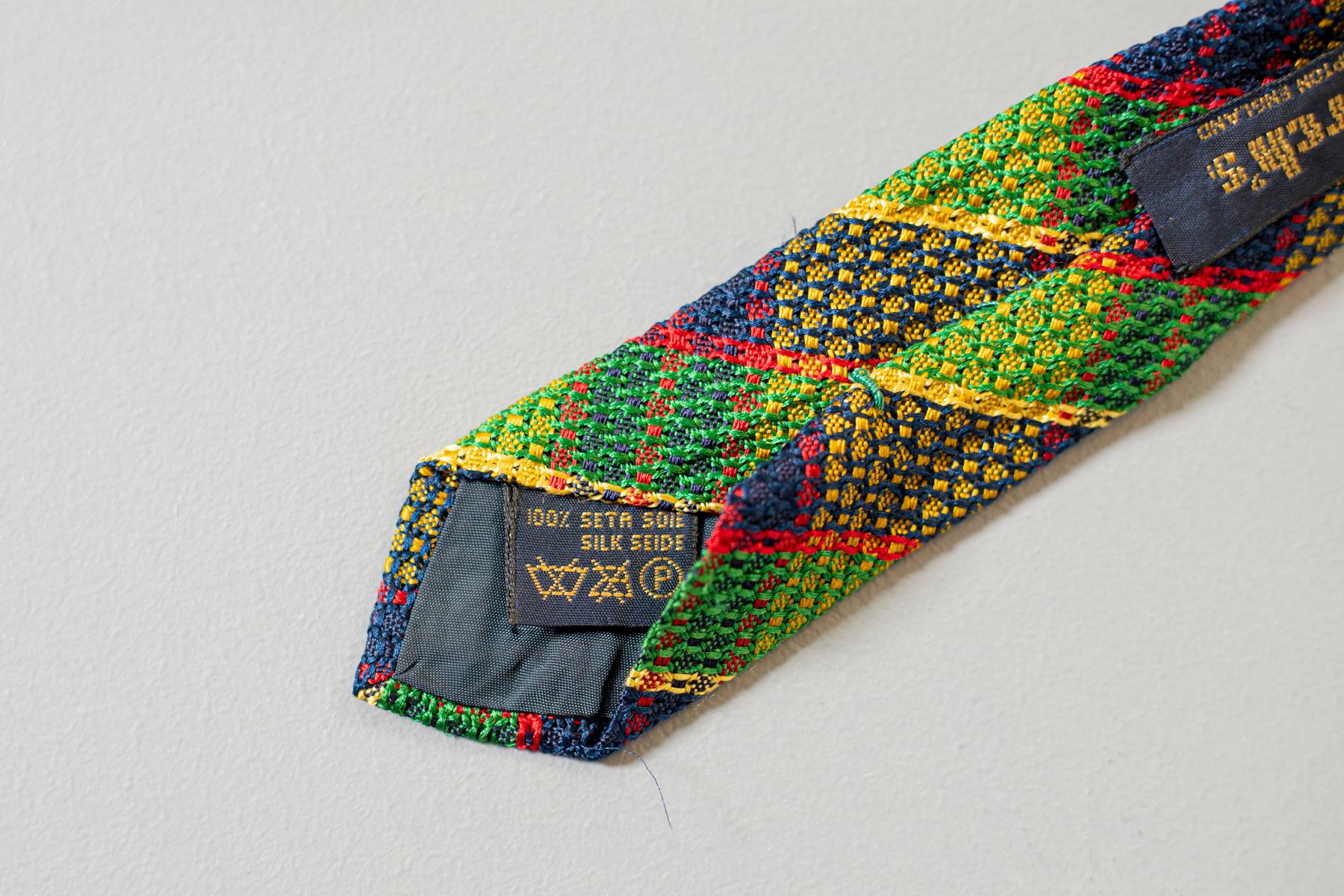 Colourful and showy, this tie displays a jacquard plaid motif in green, red, yellow, and blue. Designed by Church’s and made in Northampton England, this is a fine piece of clothing. This tie is the combination between classical and eccentric style,