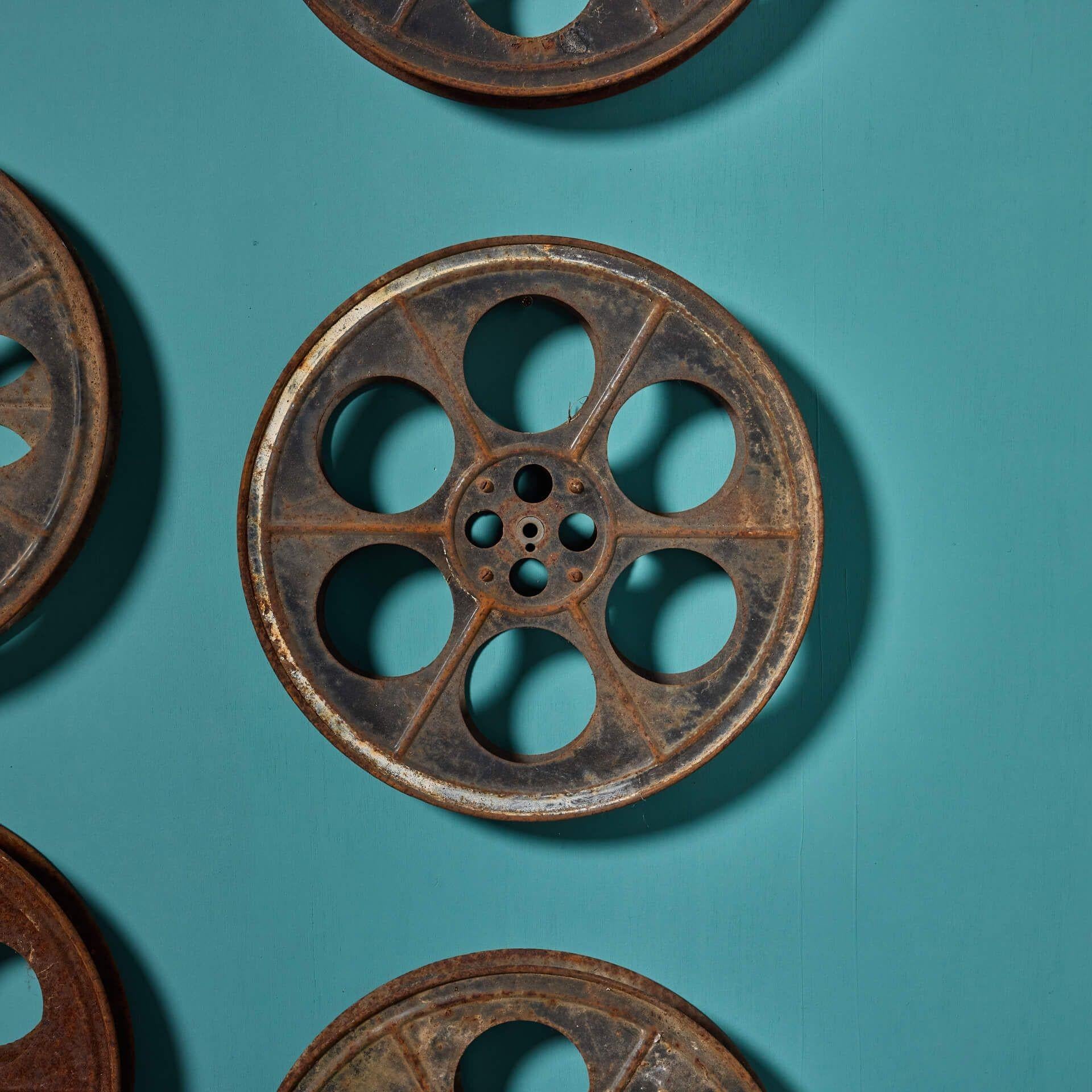 Eine Sammlung von neun Kinoprojektionsspulen aus gepresstem Stahl. Einer mit der Aufschrift 