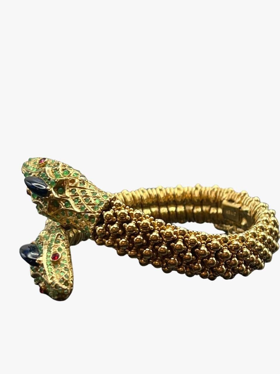 Vintage gold plated bracelet by Ciner features two interlocking snake heads embedded with red, green and blue rhinestones. 
Signed. 
Period: 1960s
Condition: excellent. No visible signs of wear. 
Size: 18 cm

........Additional information