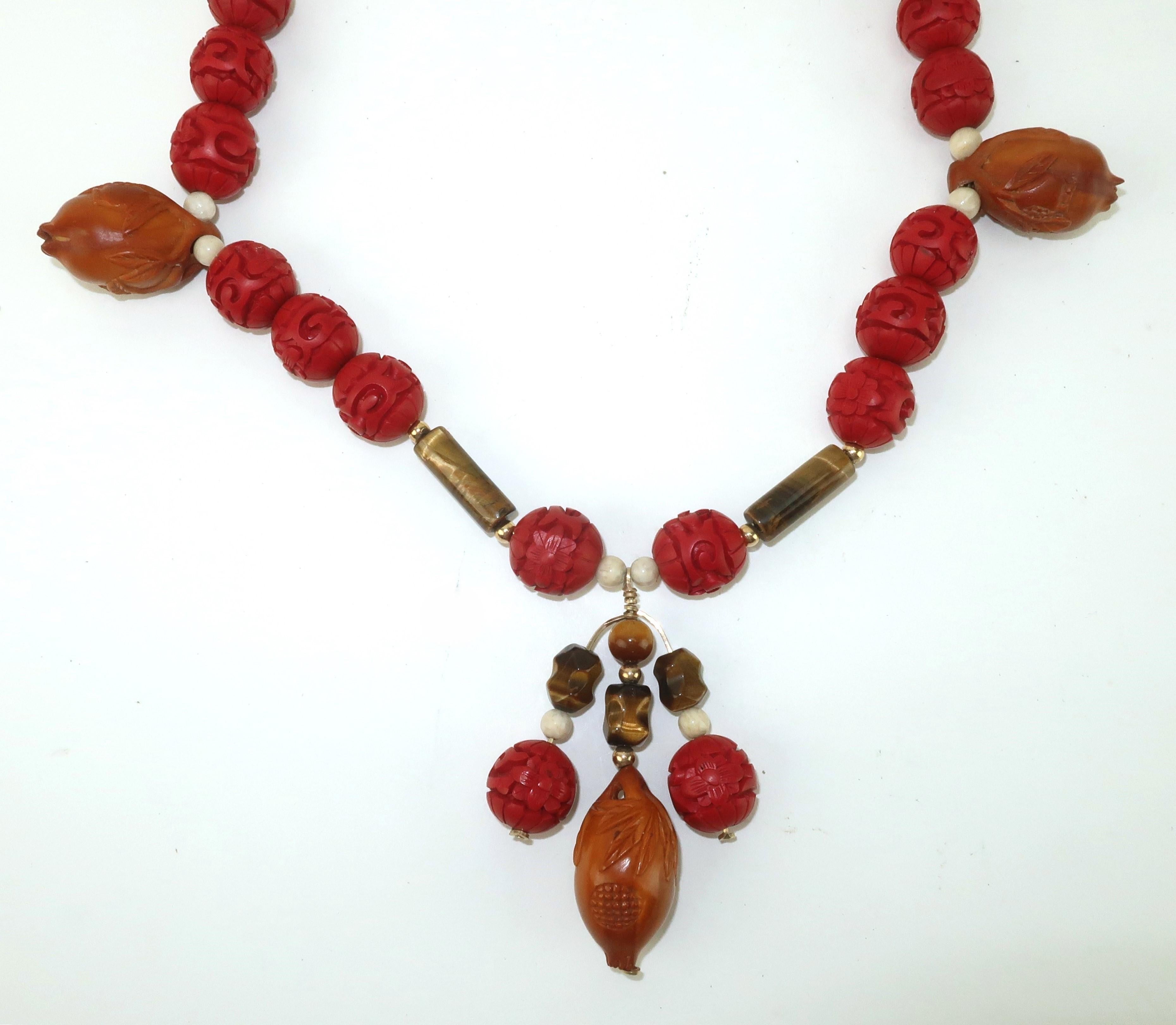 Vintage Asian cinnabar bead necklace with tiger’s eye and agate accents.  Three carved wood lotus buds add a unique look that is both organic and exotic.  A filigreed gold tone fish hook safety clasp provides a secure closure.  No maker’s