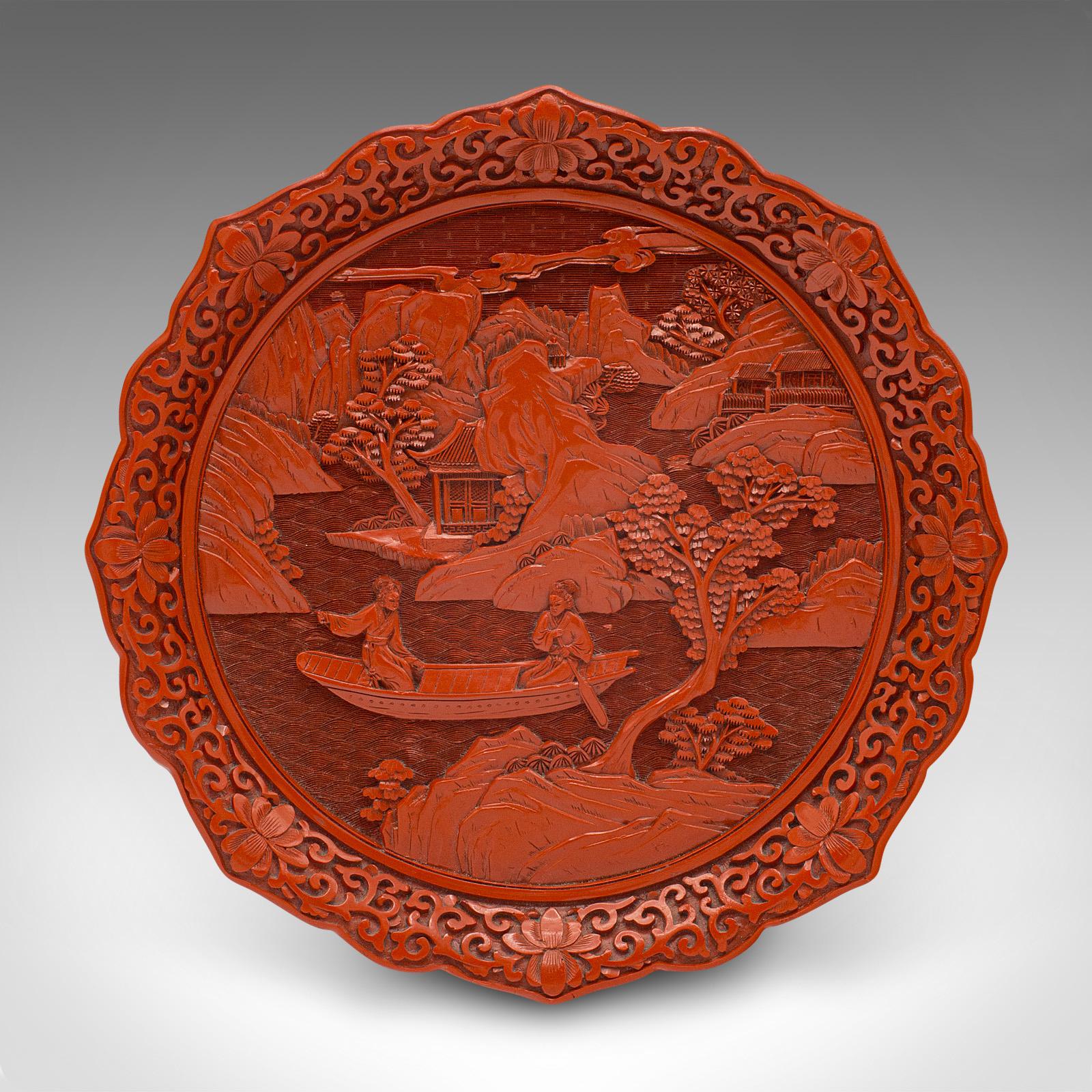This is a vintage Cinnabar display plate. A Chinese, decorative serving dish, dating to the late 20th century, circa 1980.

Striking carved detail and superb colour
Displays a desirable aged patina and in good order
Rich red hues profusely