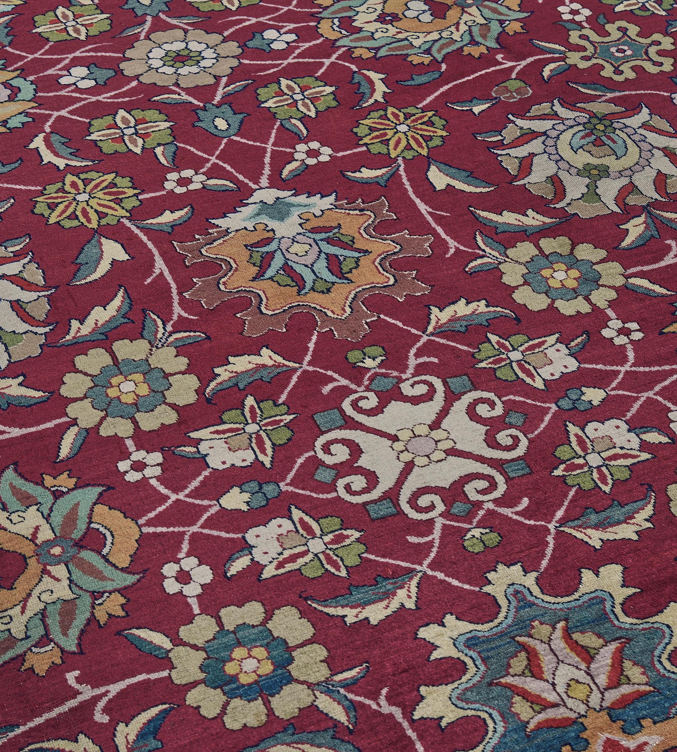 Questo Tabriz persiano d'epoca, risalente al 1920 circa, ha un campo rosso bordeaux con un disegno generale di tavolozze policrome in grassetto collegate da una fascia floreale e frondosa, in un'ampia bordura di cartigli sfumati rossi e gialli