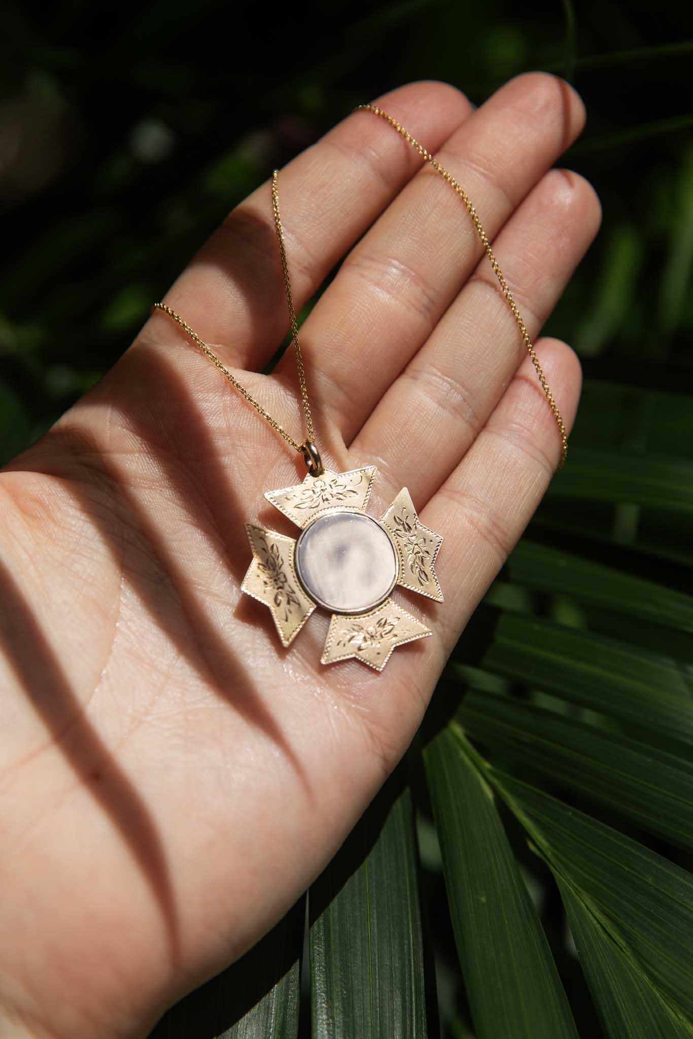 Il nostro ciondolo premio con croce arrugginita, realizzato in oro a 9 carati, offre un tocco di sobria eleganza. Delicate incisioni floreali adornano i bracci della croce, incorniciando un disco centrale liscio. Questo ciondolo è più di un
