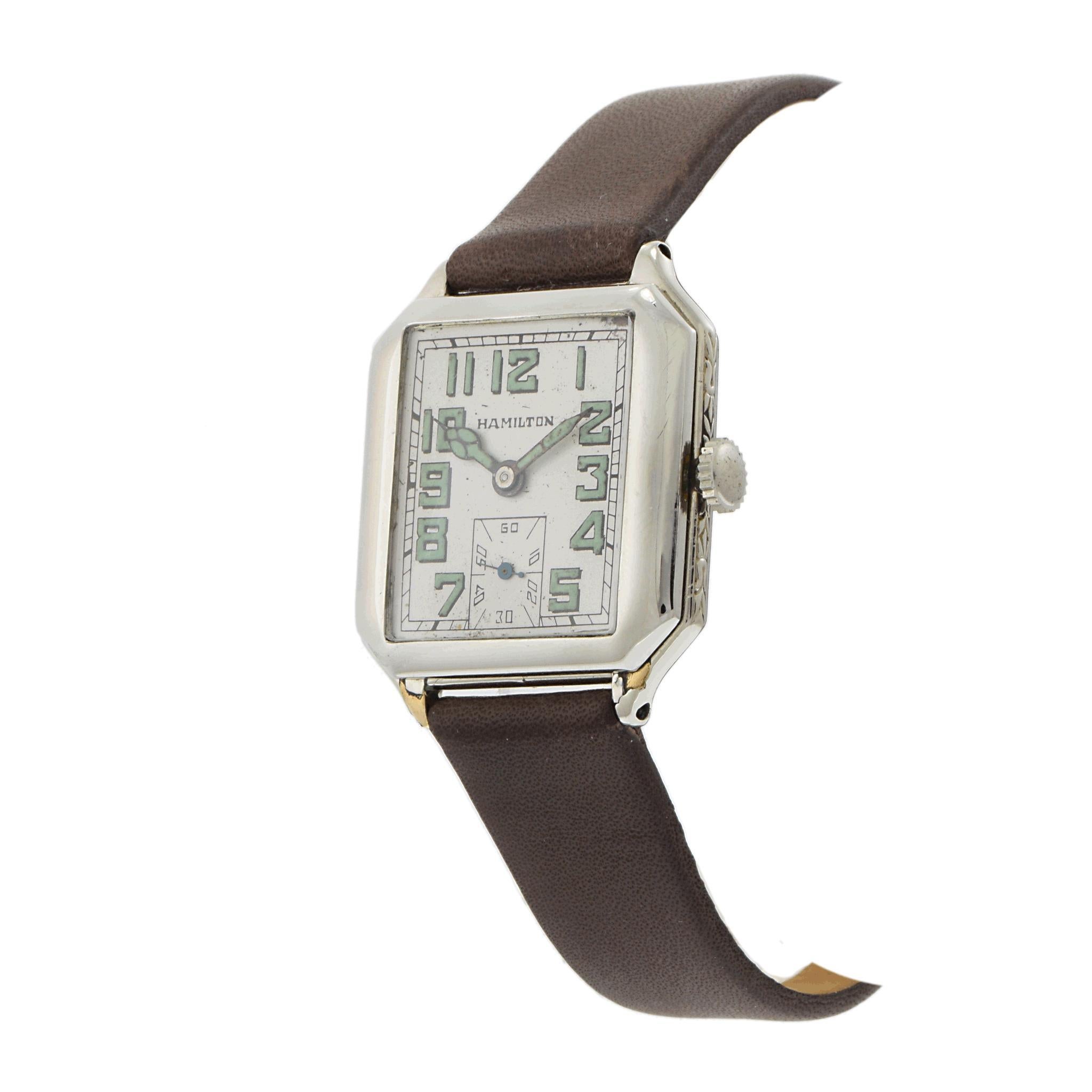 A classic Hamilton timepiece from the 1940s, featuring a 29 x 29mm 14K white gold-filled case with a distinctive square design. The silver dial is accented with luminous Arabic numerals and a sub-dial for the seconds, offering both functionality and