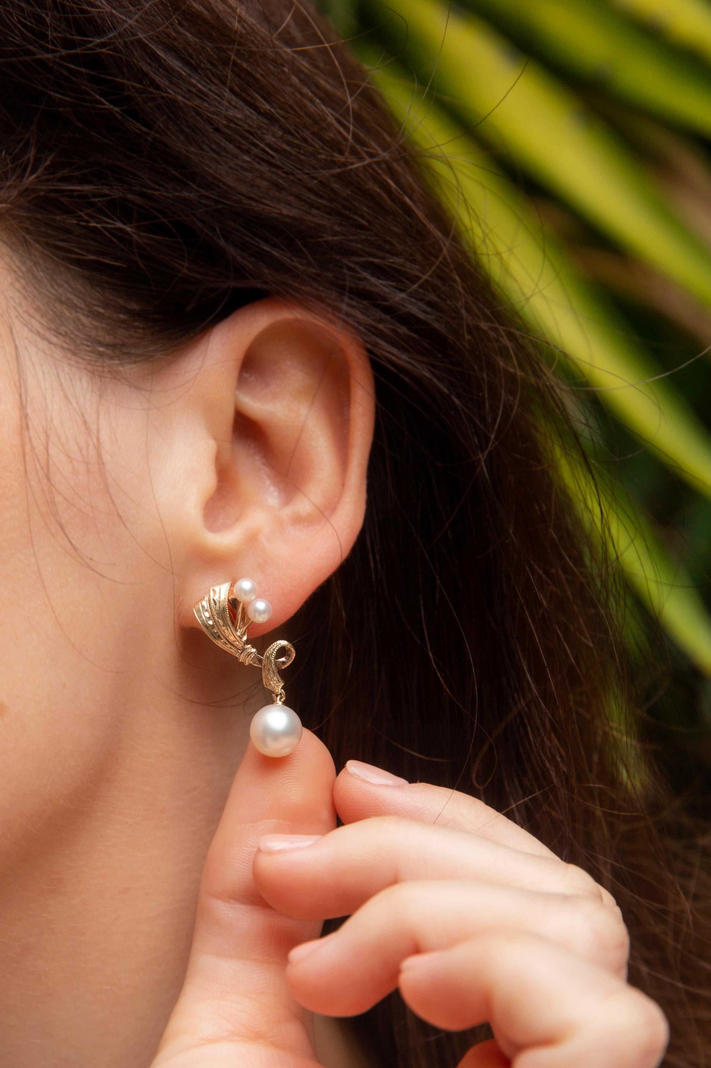 Crafted with love in 9 carat gold, these gorgeous drop earrings are each a twisting ribbon-like setting with a single white cultured pearl suspended from the bottom and a duo of smaller pearls near the top. They have been named The Lucia Earrings.