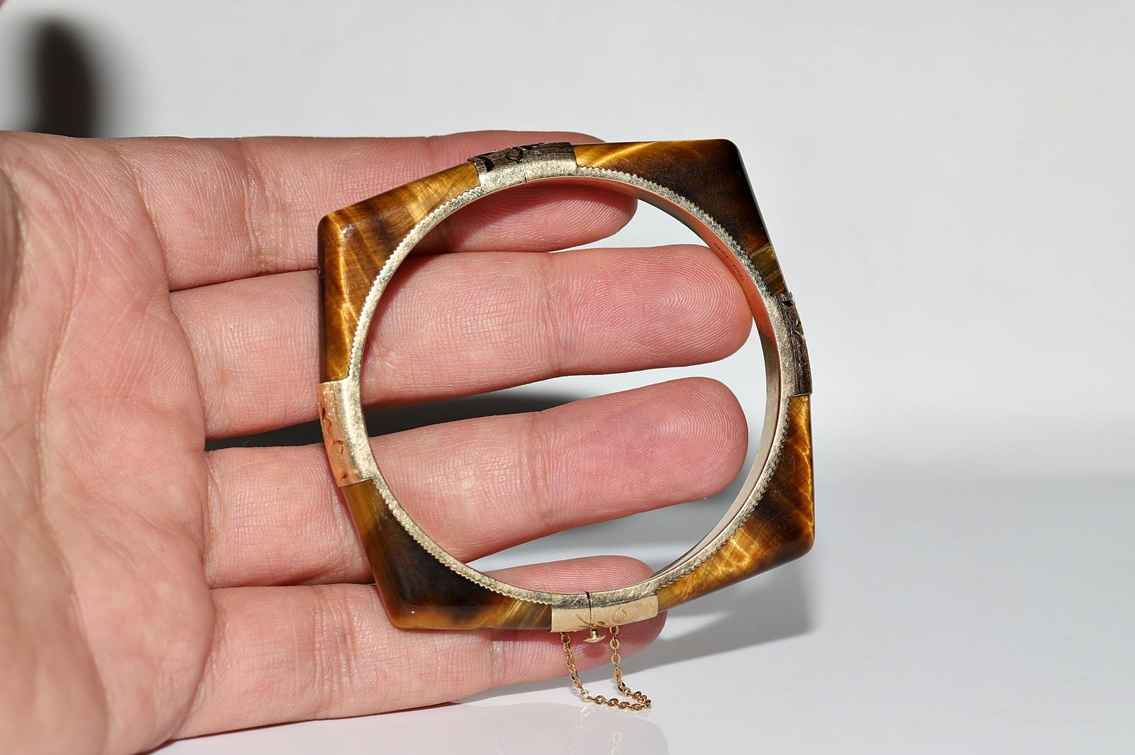 Vintage Circa 1960s 14k Gold Natural Tiger Eyes Decorated Bangle Bracelet

In very good condition.
Total weight is 32.7 grams.
Please contact for any questions.