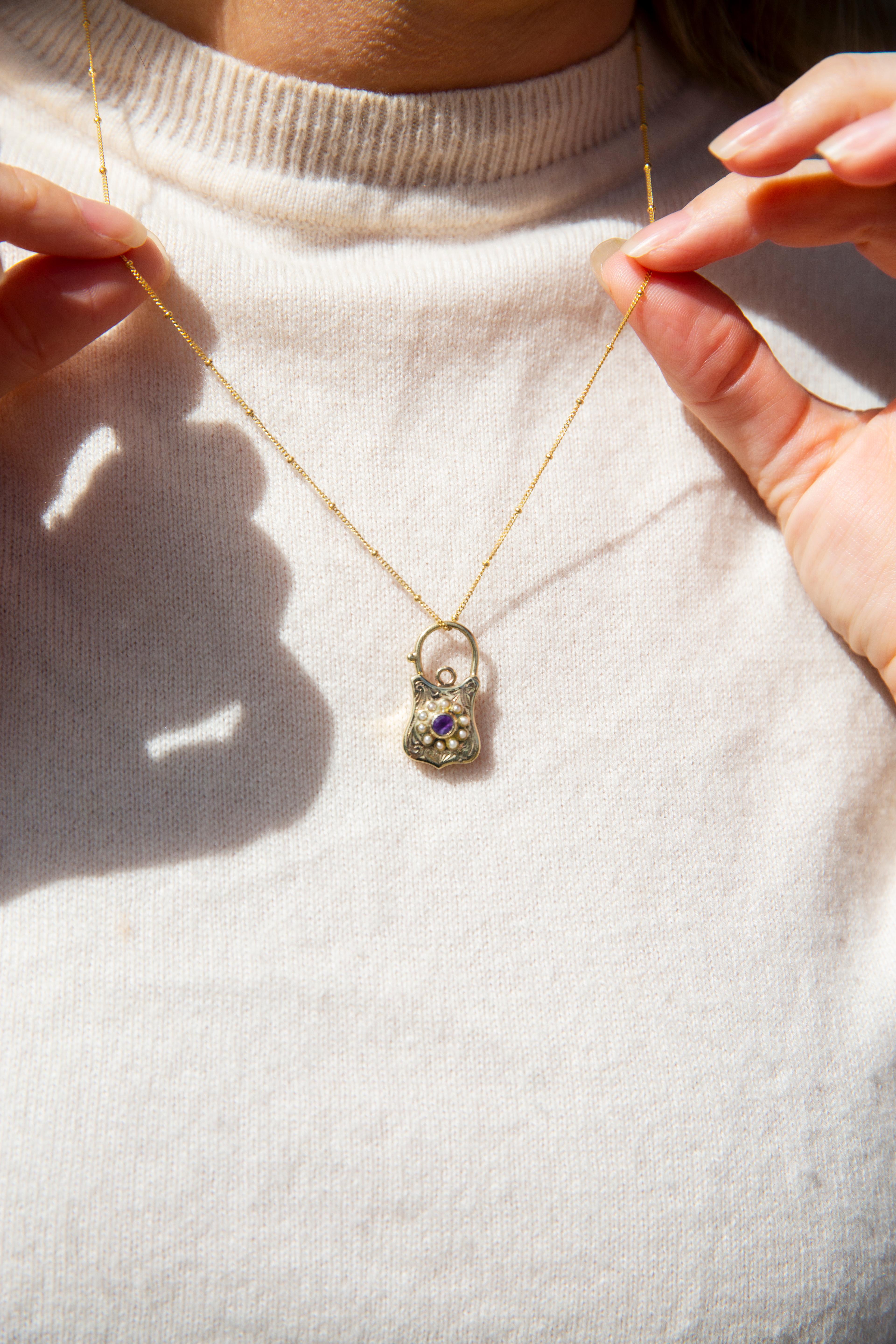 The Andree Pendant is lovingly crafted in 9 carat gold, her decoratively etched front framing an alluring amethyst and seed pearl flower. A sweet vintage inclusion in any collection.

The Andree Pendant & Chain Gem Details
The faceted round bright