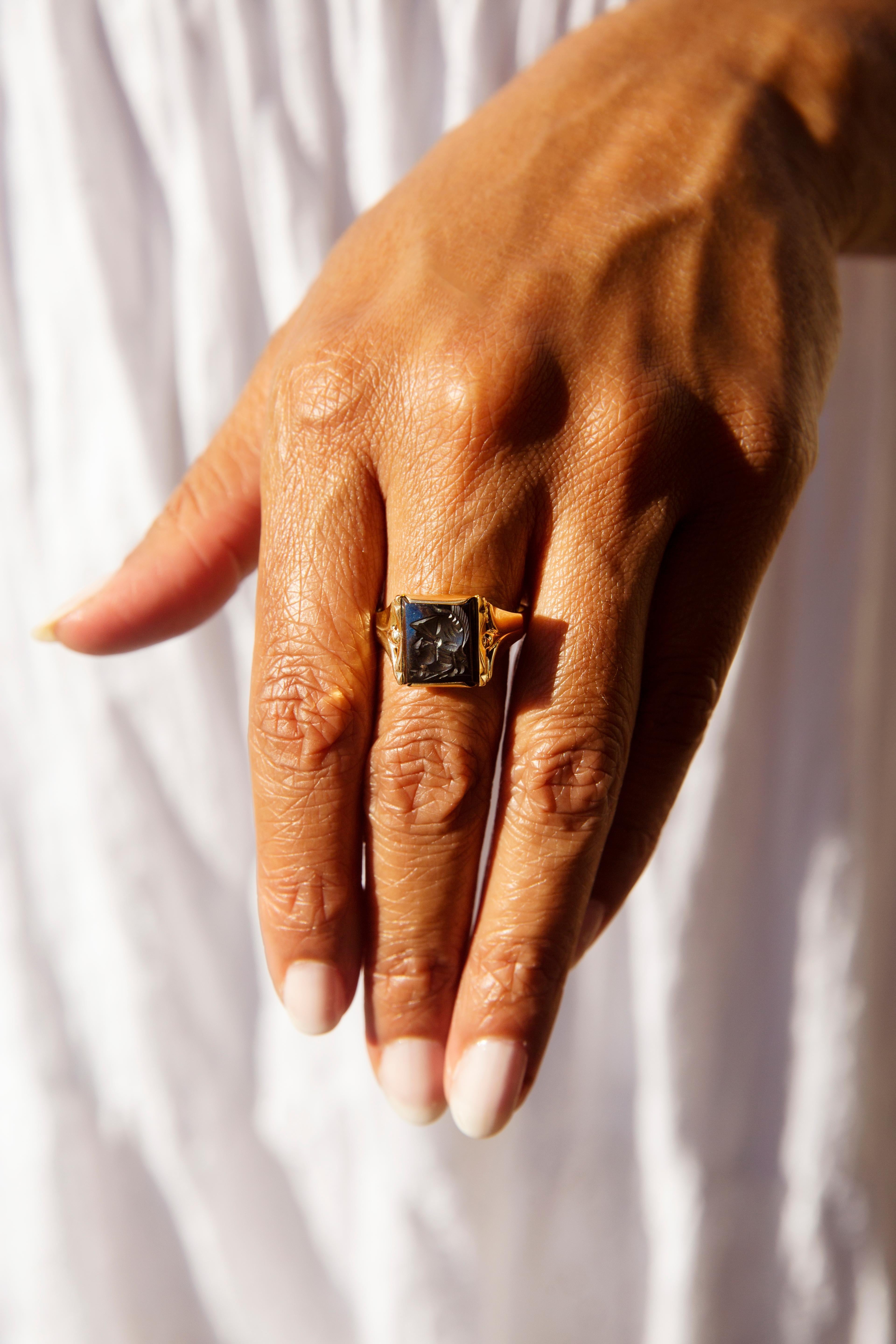 Forged in 9 carat yellow gold, this stylish flared ring features a bold rectangular hematite with an intaglio of a Roman centurion incised into the centre. Her name is The Max Ring. Her centrepiece intaglio symbolises bravery and intrepidation,