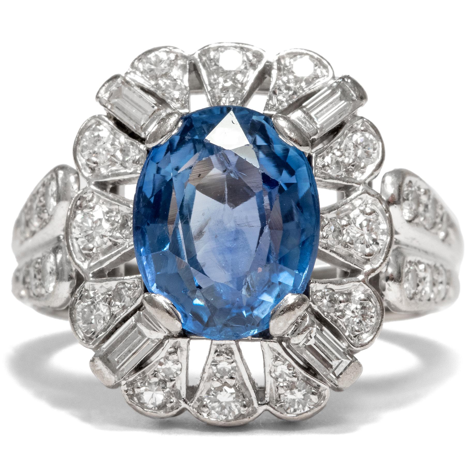 This vintage ring, created circa 1970, is a beautiful variation on the classic combination of diamonds and blue sapphire. 40 diamonds in varying cuts, amounting to an overall weight of approximately a carat, frame the large central sapphire of 5.80