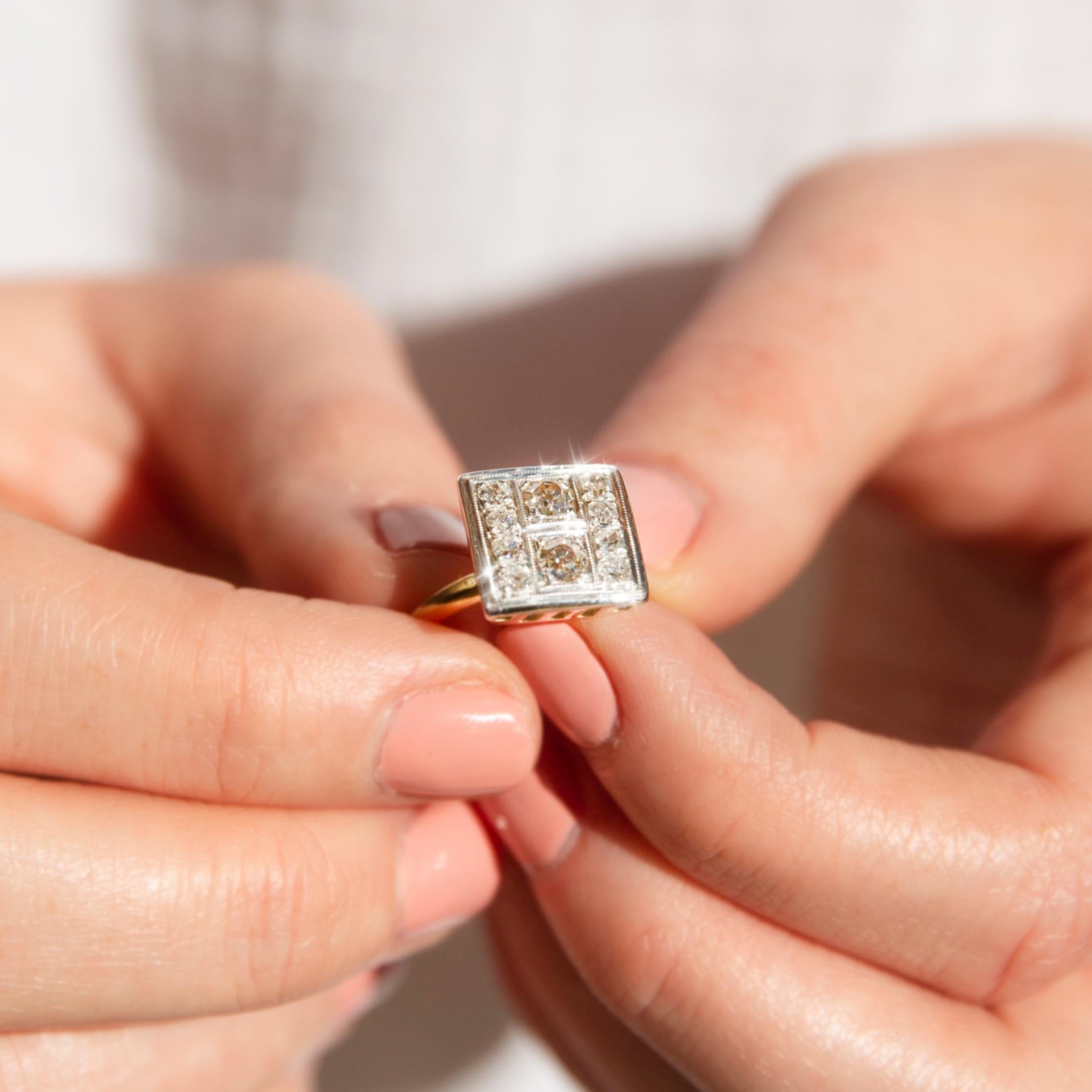 Dieser bezaubernde Ring aus 18 Karat Gold hat eine quadratische Fassung mit einem Duo von Diamanten im Altschliff in der Mitte, flankiert von zehn runden Diamanten im Brillantschliff, die im Einklang miteinander schimmern. Ihr Name ist The Emmalynn