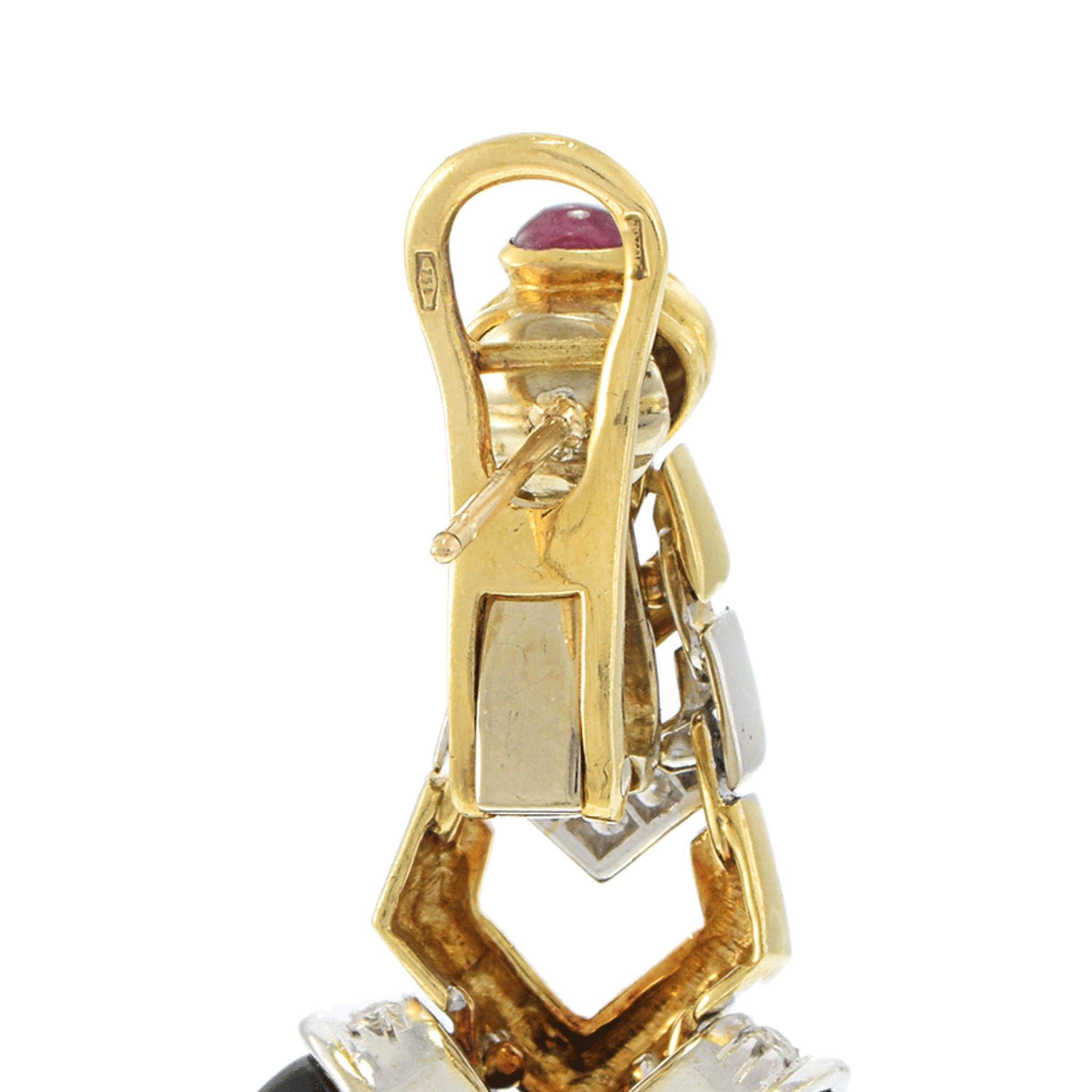 A bold and beautifully crafted pair of circa 1970s vintage drop earrings, made in 18KT two-tone gold and showcasing a striking combination of materials and design. Each earring features black onyx accents, paired with 0.60CT-TW of vivid cabochon-cut
