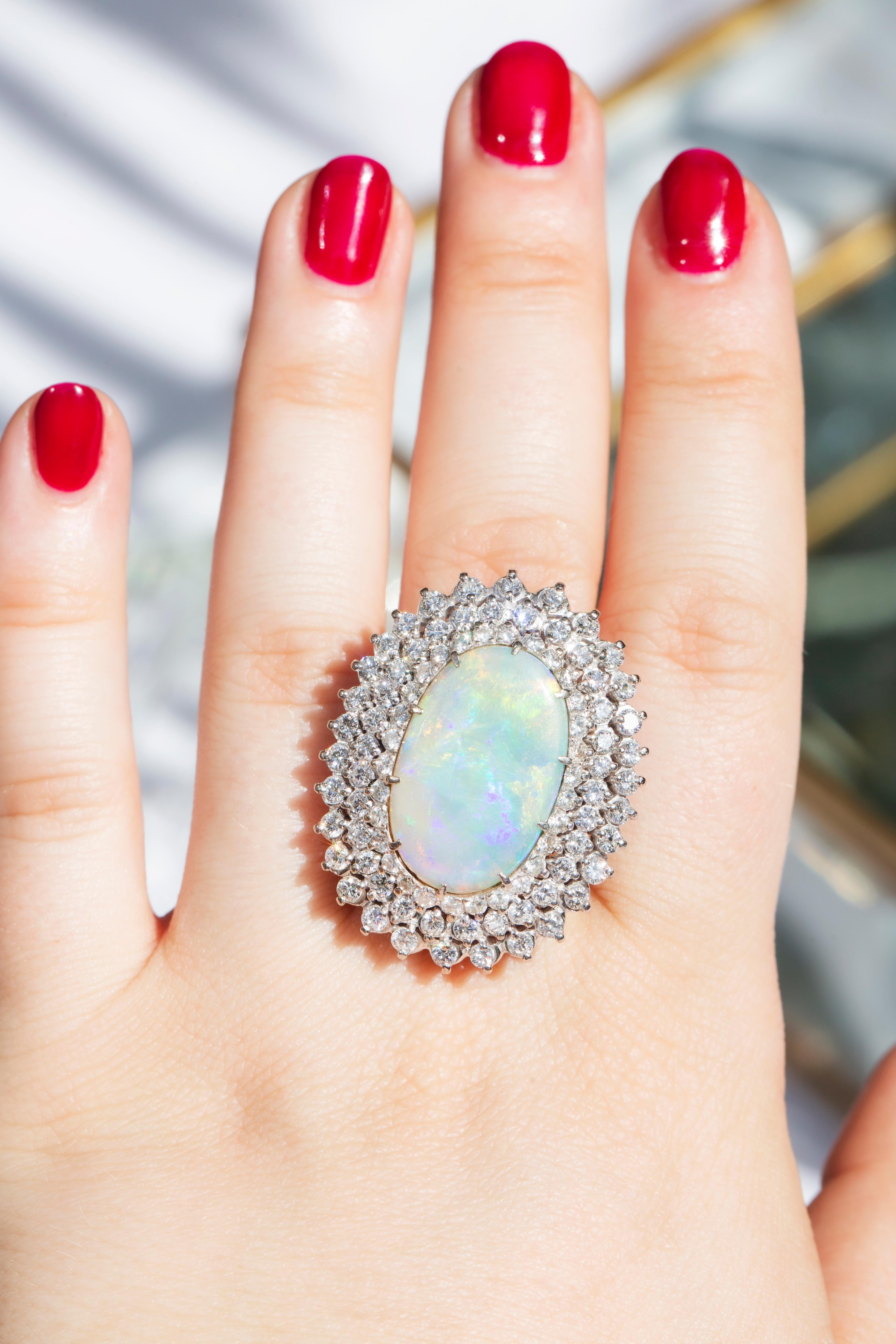 Embodying the romance and beauty of the Australian outback and crafted in 18 carat gold, this stunning vintage opal ring is surrounded by processions of sparkling white diamonds. Flashing blue, red and green, reminders of sunsets on heavenly summer