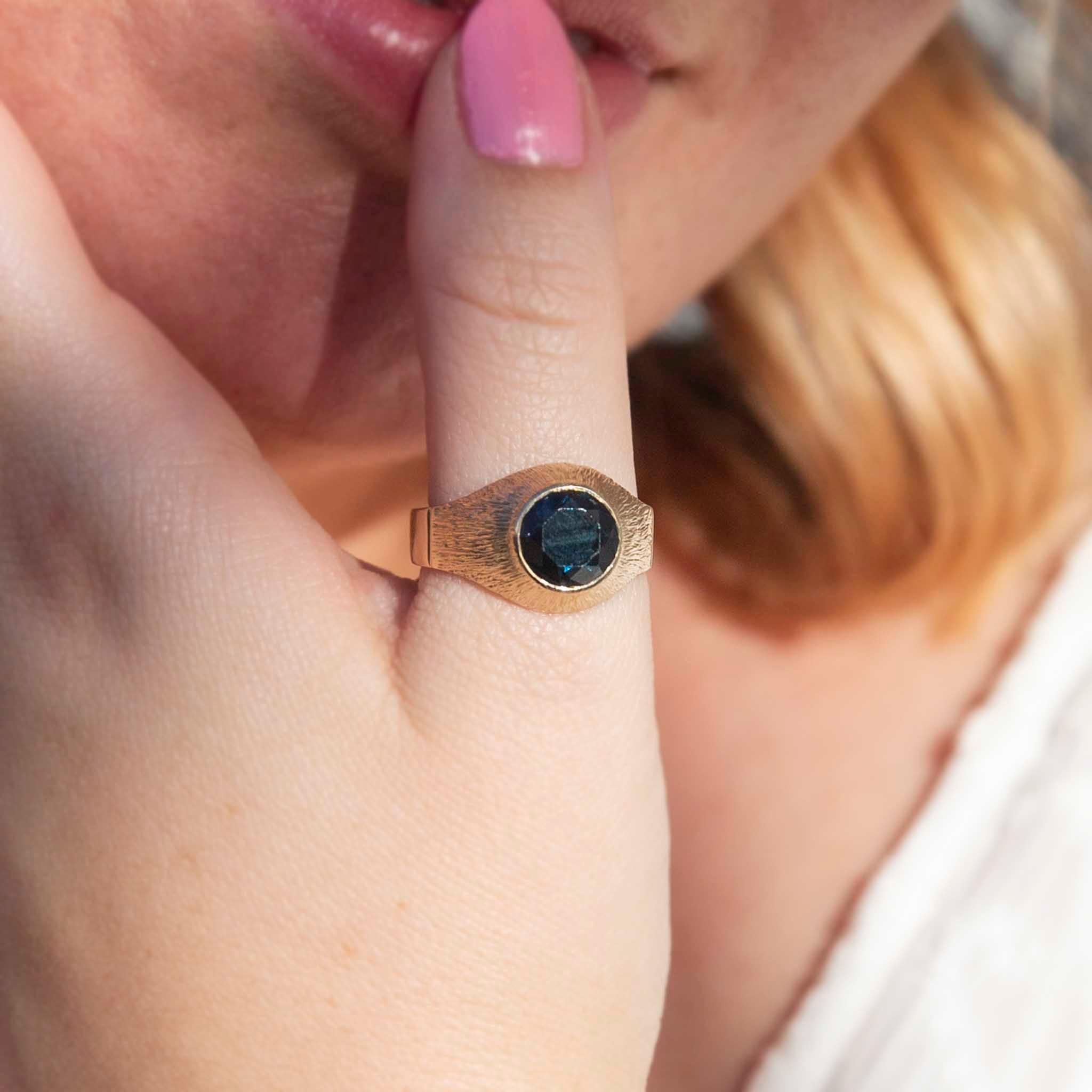 Forged in 9 carat gold, this vintage ring features a deep greenish-blue Australia-type sapphire at the top of a textured dome setting. We have named her The Thiago Ring. She is a wonderfully bold statement ring and is sure to find a beloved place in
