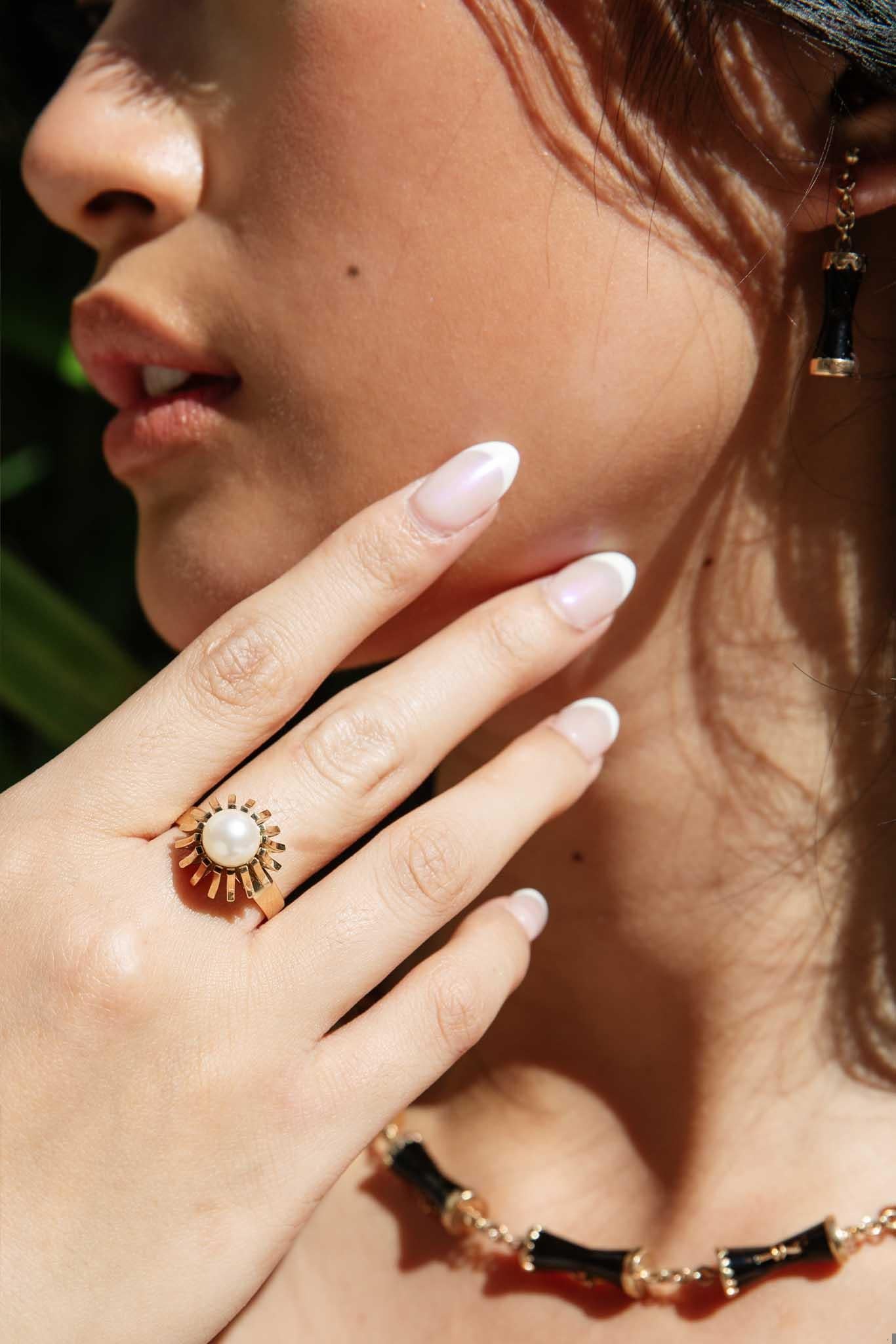 A lovely freshwater pearl exuding soft overtone hues of green and pink rests atop The Amelie Ring in an elegant chandelier-style setting. As unique as the one who wears her, she is sure to become a beloved favourite.

The Amelie Ring Gem Details
The
