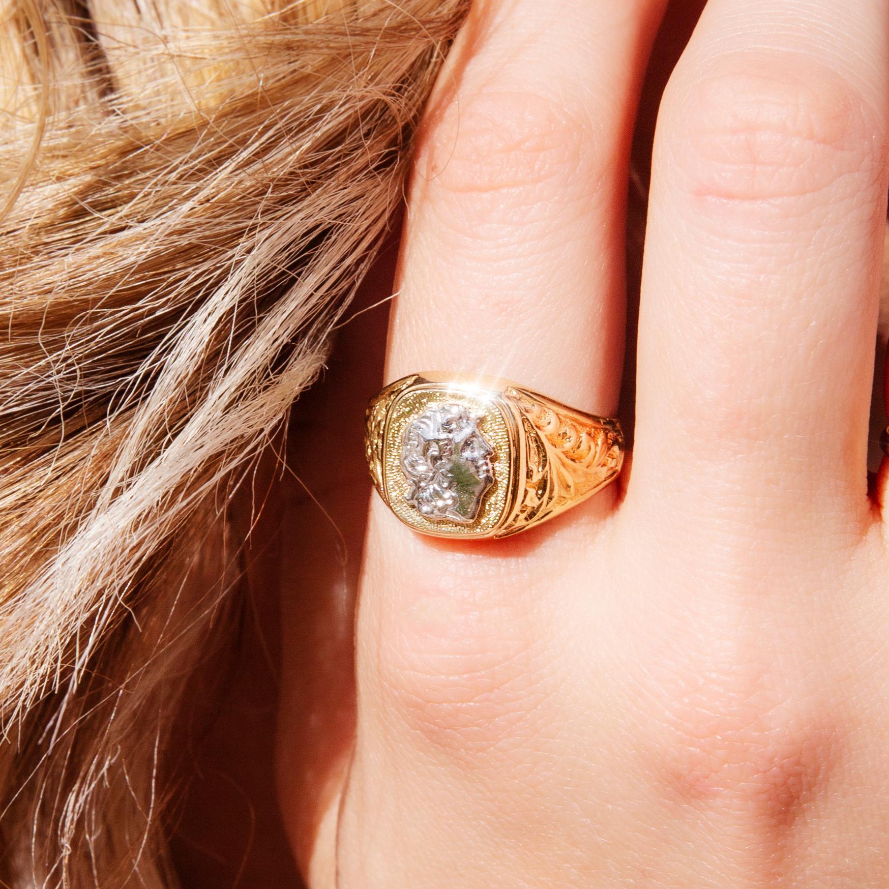 Dieser stattliche Siegelring aus 14-karätigem Gold aus den 1980er Jahren ist von den Römern inspiriert. Er besteht aus einem kissenförmigen und strukturierten flachen Ring aus Gelbgold mit dem erhabenen Bild eines römischen Kaisers aus Weißgold.