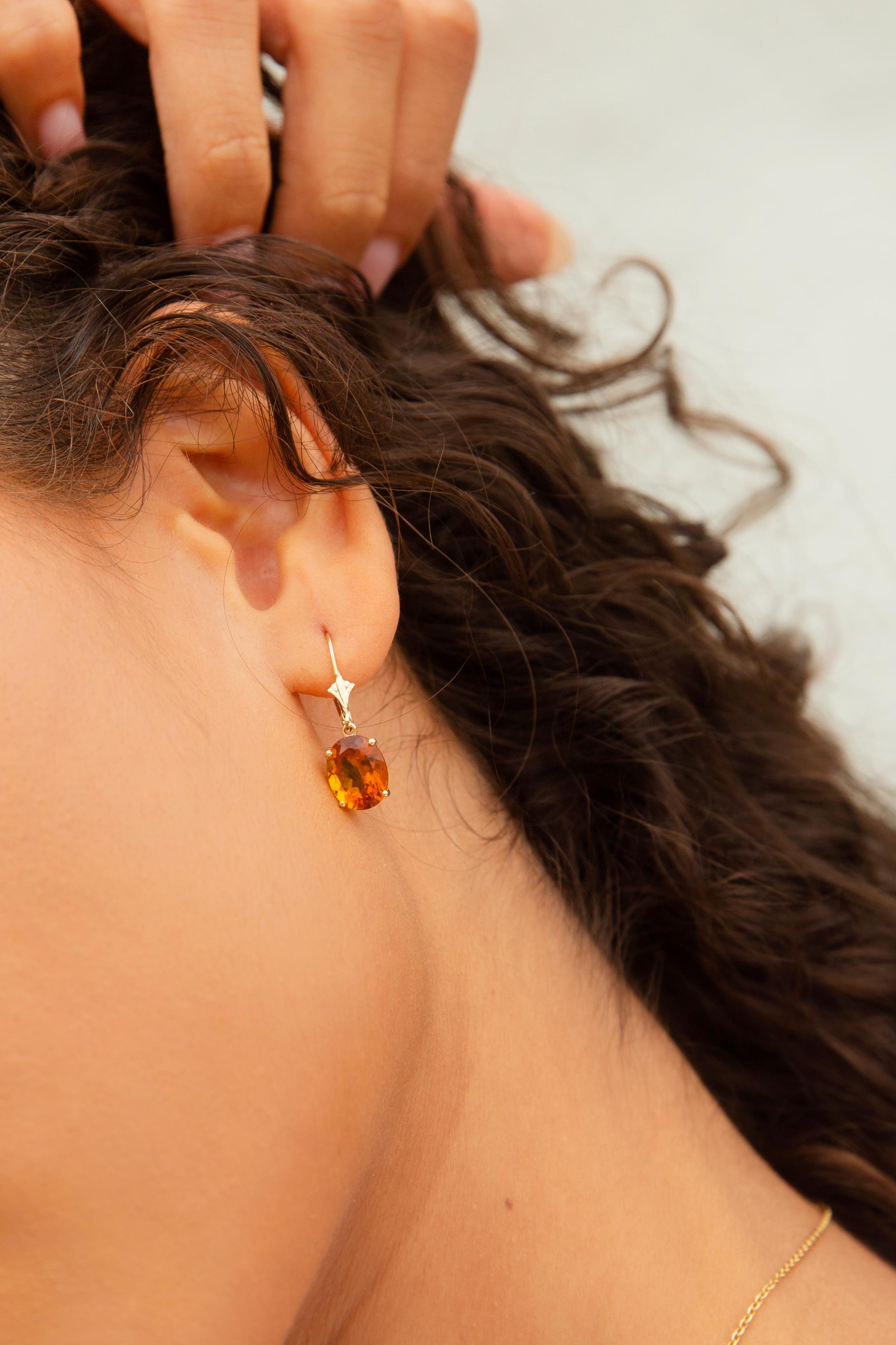 Carefully crafted in 14 carat gold, these charming vintage drop-style earrings each feature a gorgeous faceted oval bright deep orange citrine in a 4-claw basket setting with hook clip backings. We have named this wonderful pair of earrings The