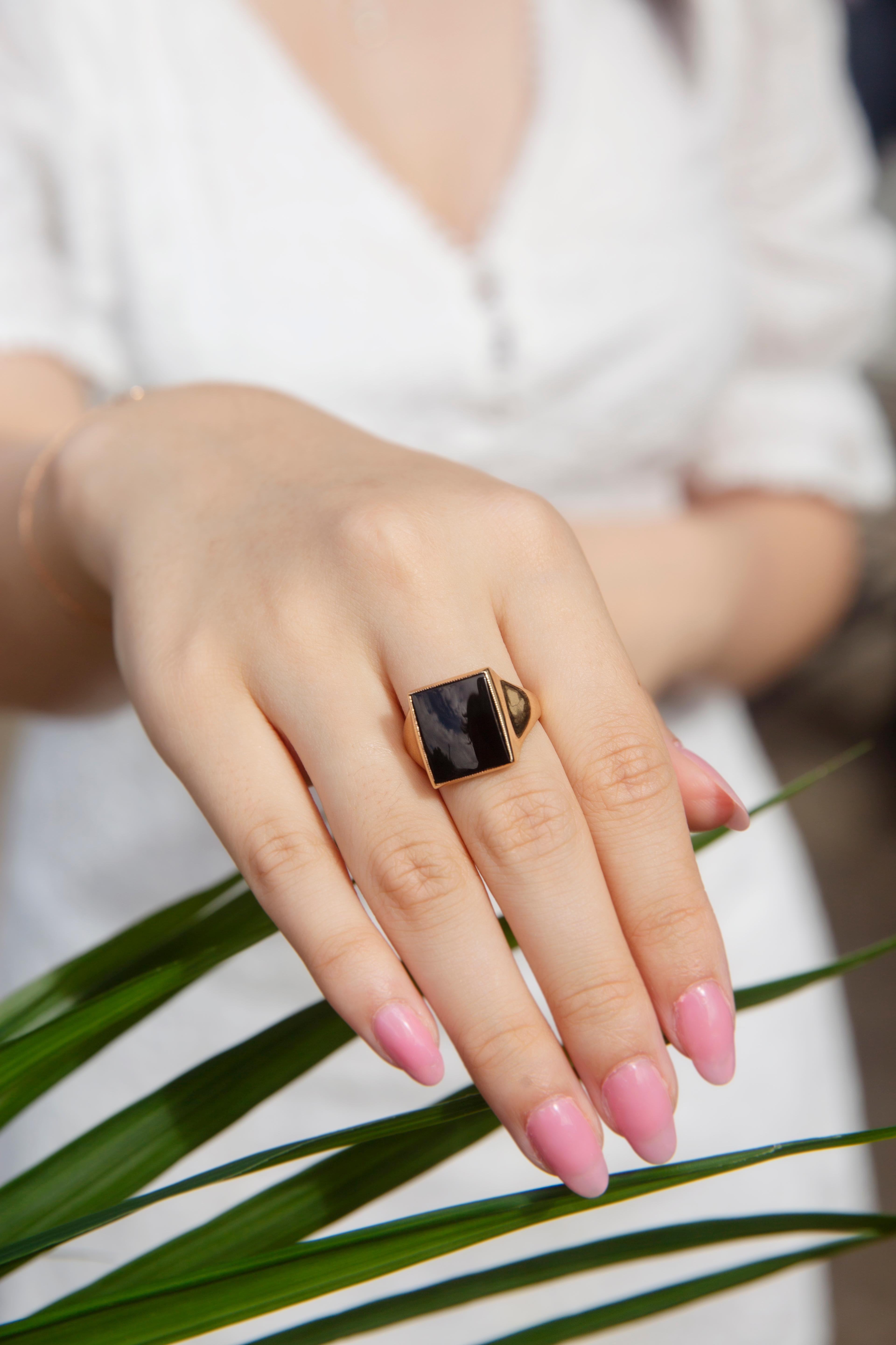 Crafted in 9 carat yellow gold, this handsome men's signet ring sees a high-polish flared band holding an opulent black rectangular buff-top onyx. We have named this debonair splendour The Rodney Ring. She slips on comfortably with a low profile, a