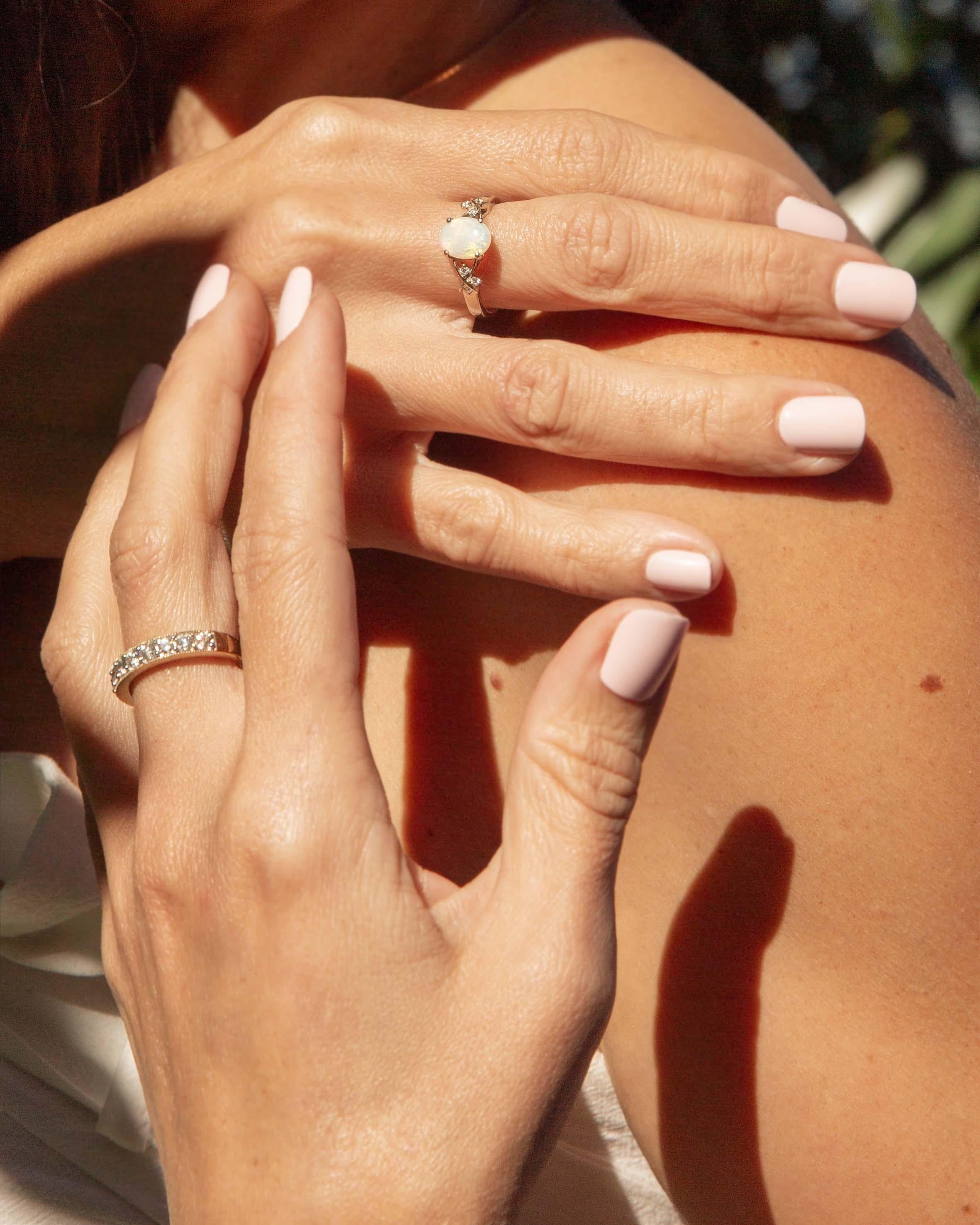 In einer Symphonie aus Licht tanzt der Ferna Crystal Opal & Diamond Ring mit ungesehenen Farben und flüstert Geschichten von fernen Ufern. Eingebettet in 14-karätiges Weißgold, spiegeln ihr Kristallopal und ihre Diamanten wirbelnde Freude und