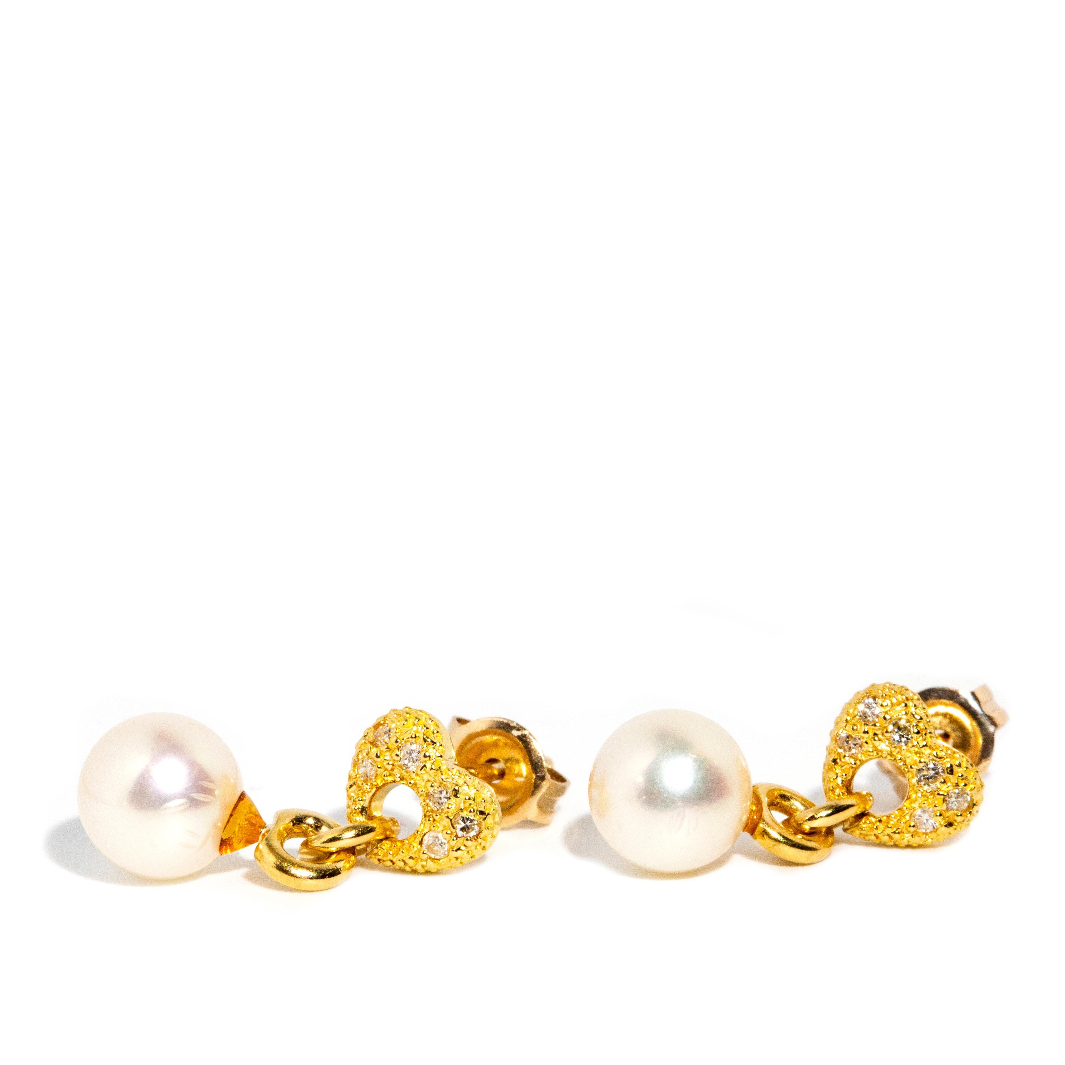 Crafted in 18 carat gold, these adorable vintage earrings each feature a plethora of diamonds in textured bubble heart settings with a gorgeous freshwater pearl suspended below. They are named The Almira Earrings. They look adorable no matter the
