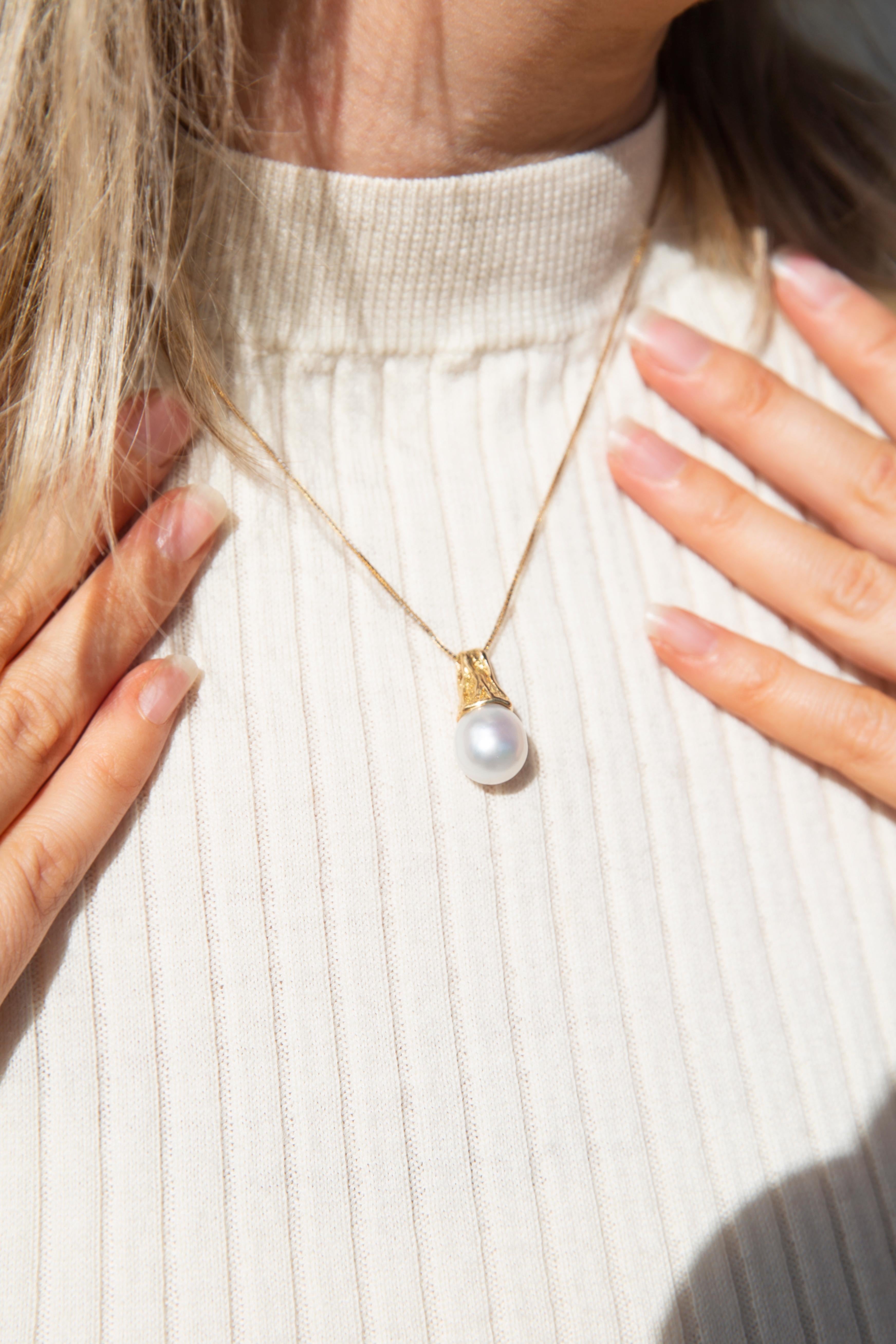 Crafted in 9 carat yellow gold, this darling pendant features a lustrous white baroque South Sea pearl in a natural rock-textured bail. She is named The Darby Pendant & Chain. She is threaded with a fine chain and evokes strong feelings of precious